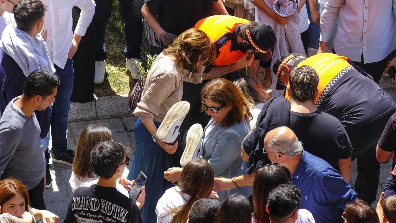 Dos miembros de Protección Civil atienden a una persona en la salida de la Borriquita.