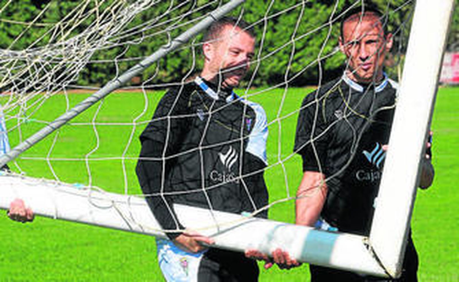 Pepe Díaz y Jorge Luque trasladan una portería, ayer.