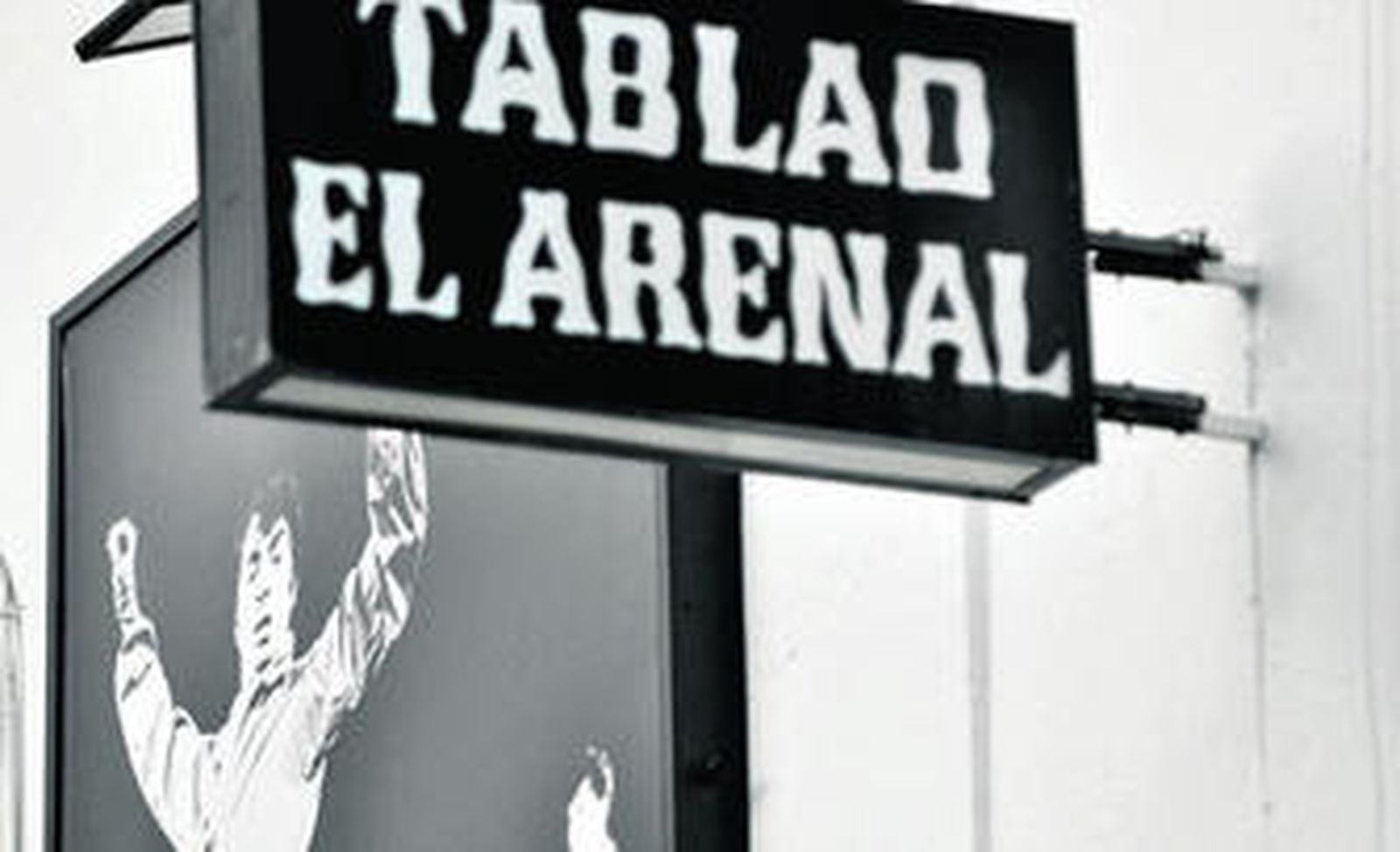 Fotografía de Curro Vélez junto al rótulo de su tablao El Arenal, abierto por el bailaor en 1975 en la calle Rodo.