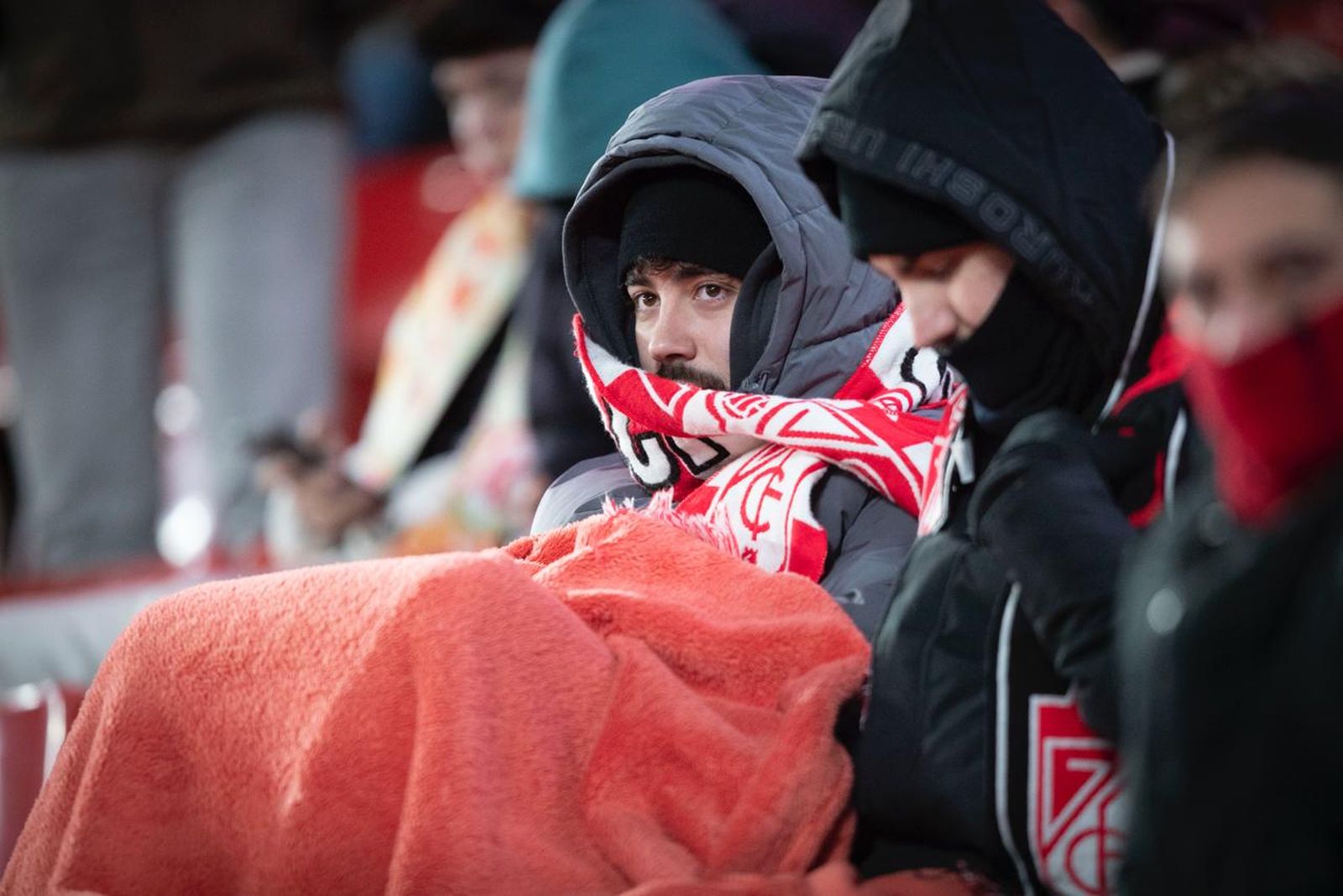 Aficionados del Granada CF protegiéndose del frío durante el partido de Copa.