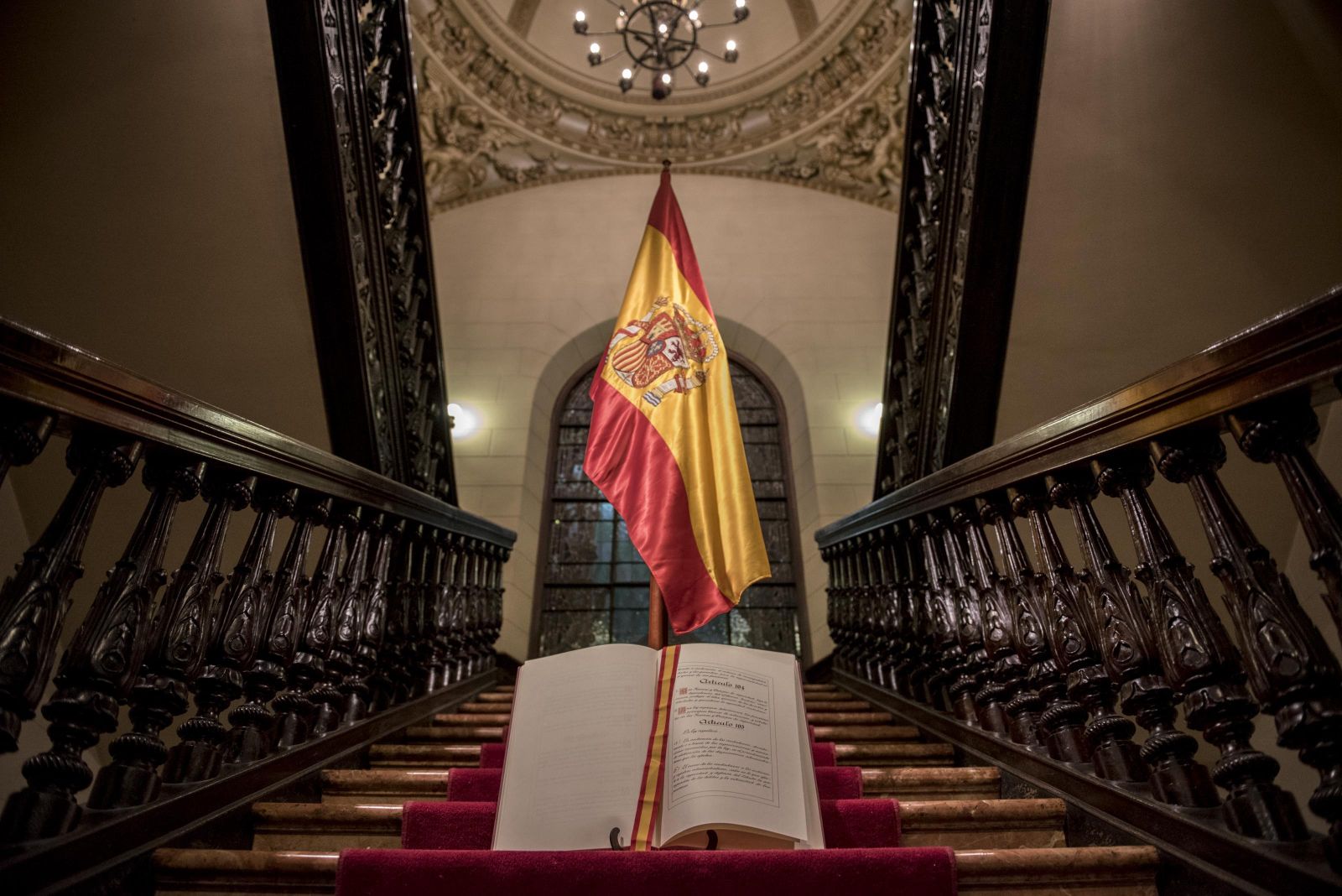 Un ejemplar de la Constitución, fotografiado junto a una bandera de España.