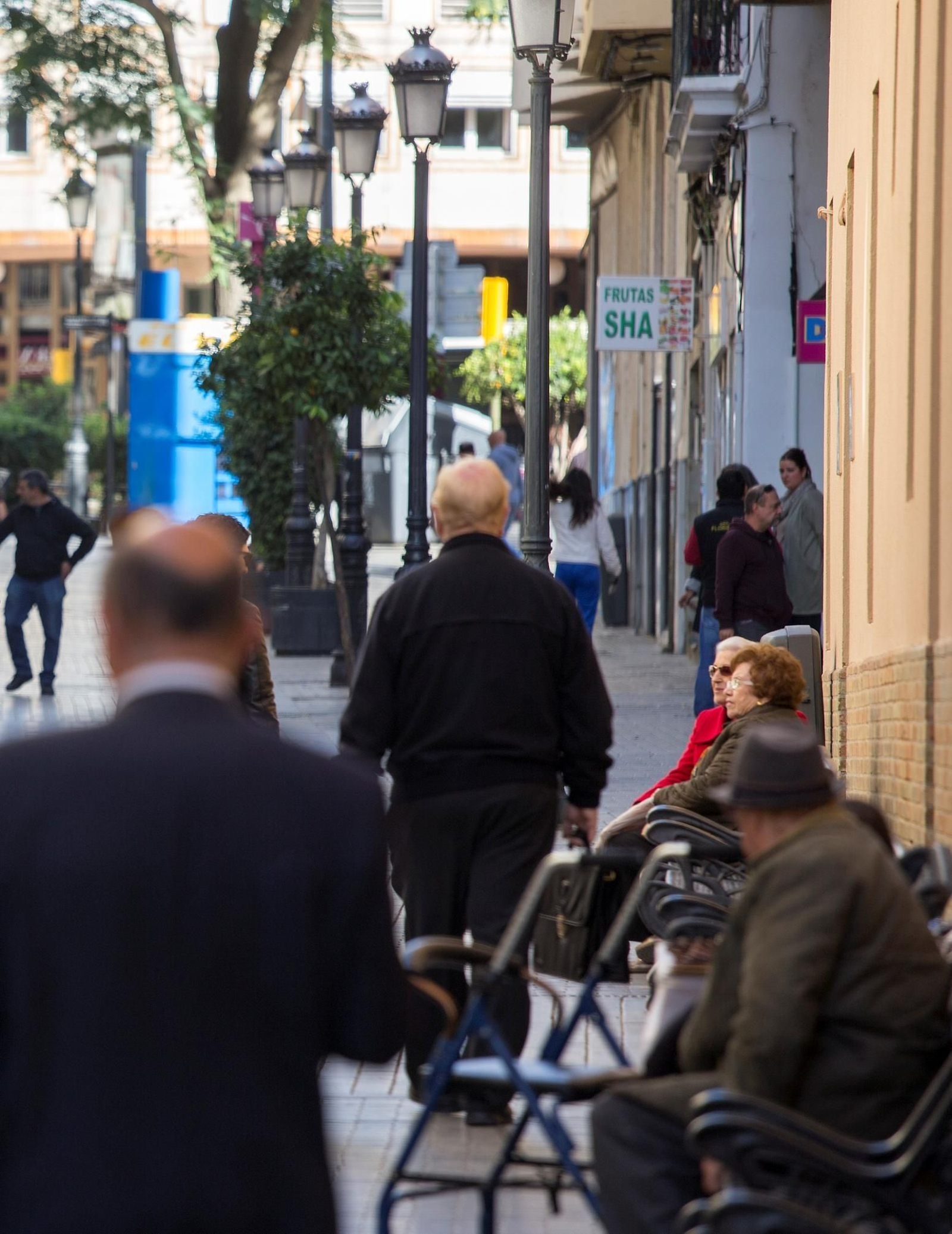 Un grupo de personas mayores en una calle de Huelva.