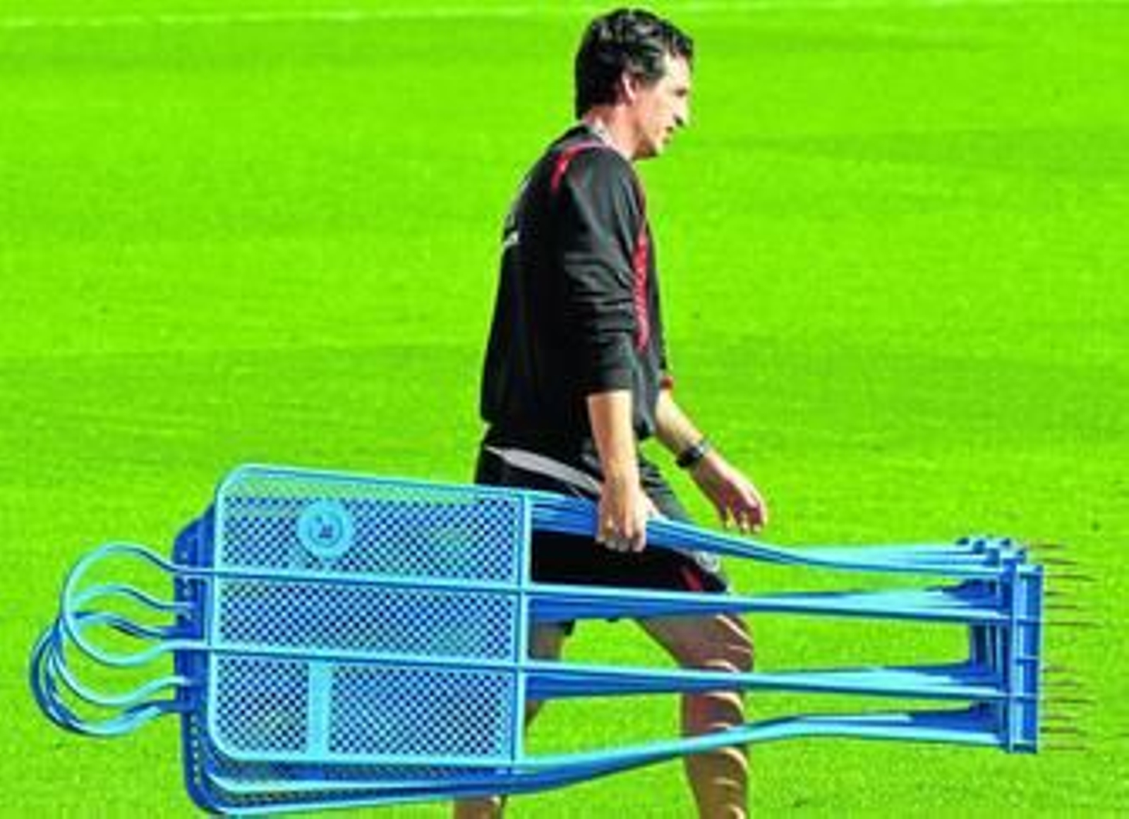 Unai Emery carga con varios muñecos para preparar la sesión de ayer en el estadio.