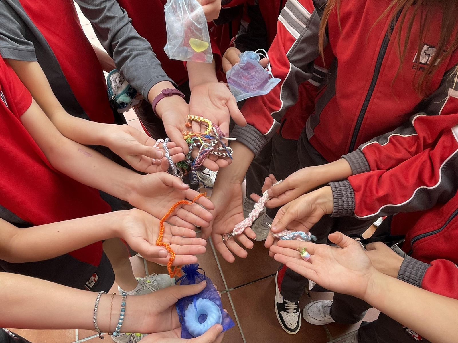 Niños enseñando las pulsera que hacen