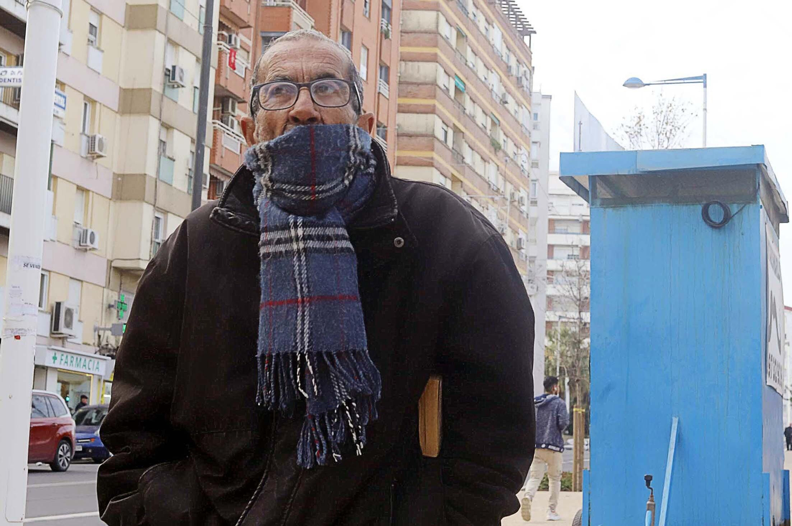 Un onubense pasea abrigado por un barrio de Huelva capital estos días