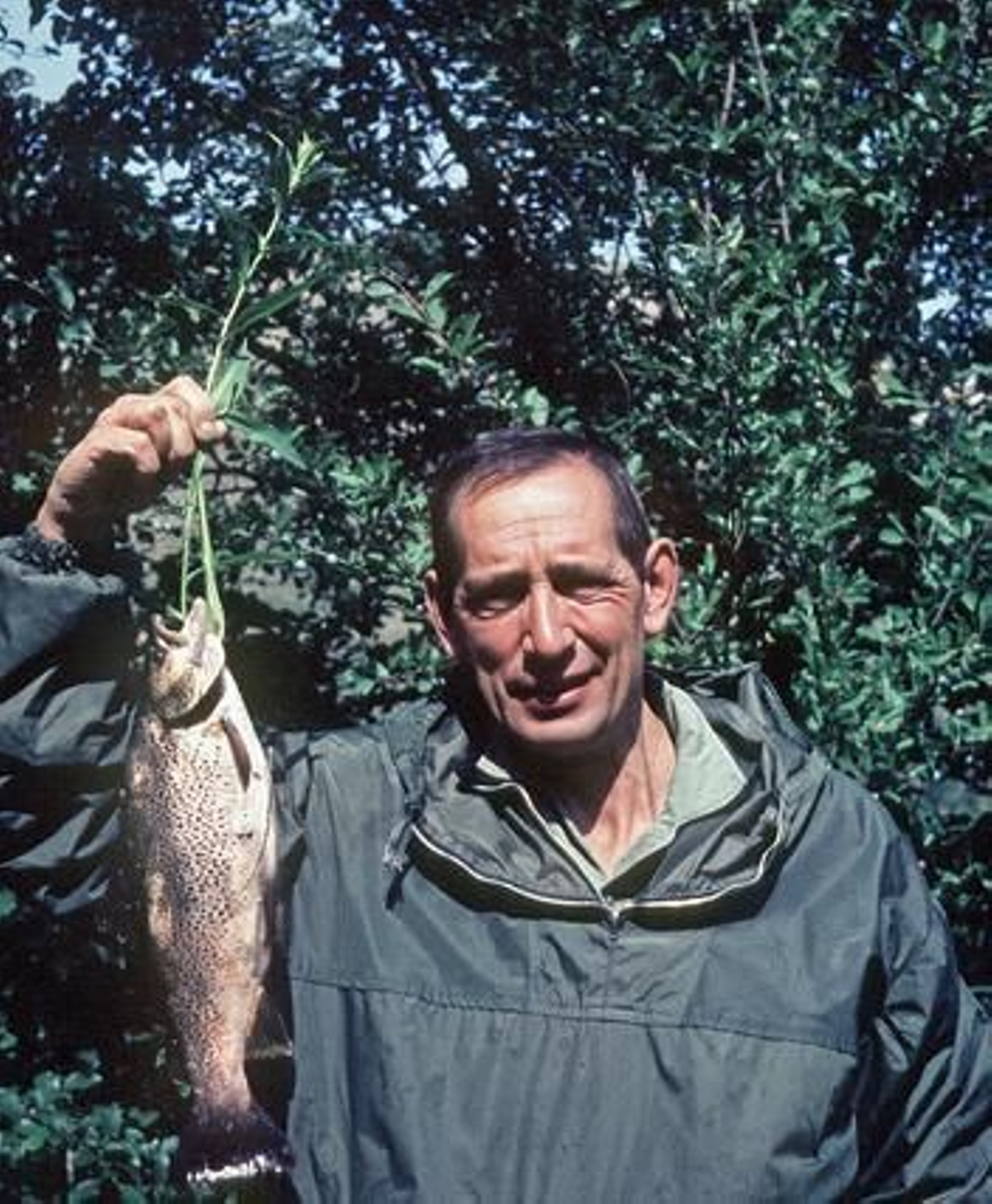 El escritor muestra orgulloso una trucha capturada durante una jornada de pesca, a la que era aficionado, en las cercanías de su ciudad natal. / EFE