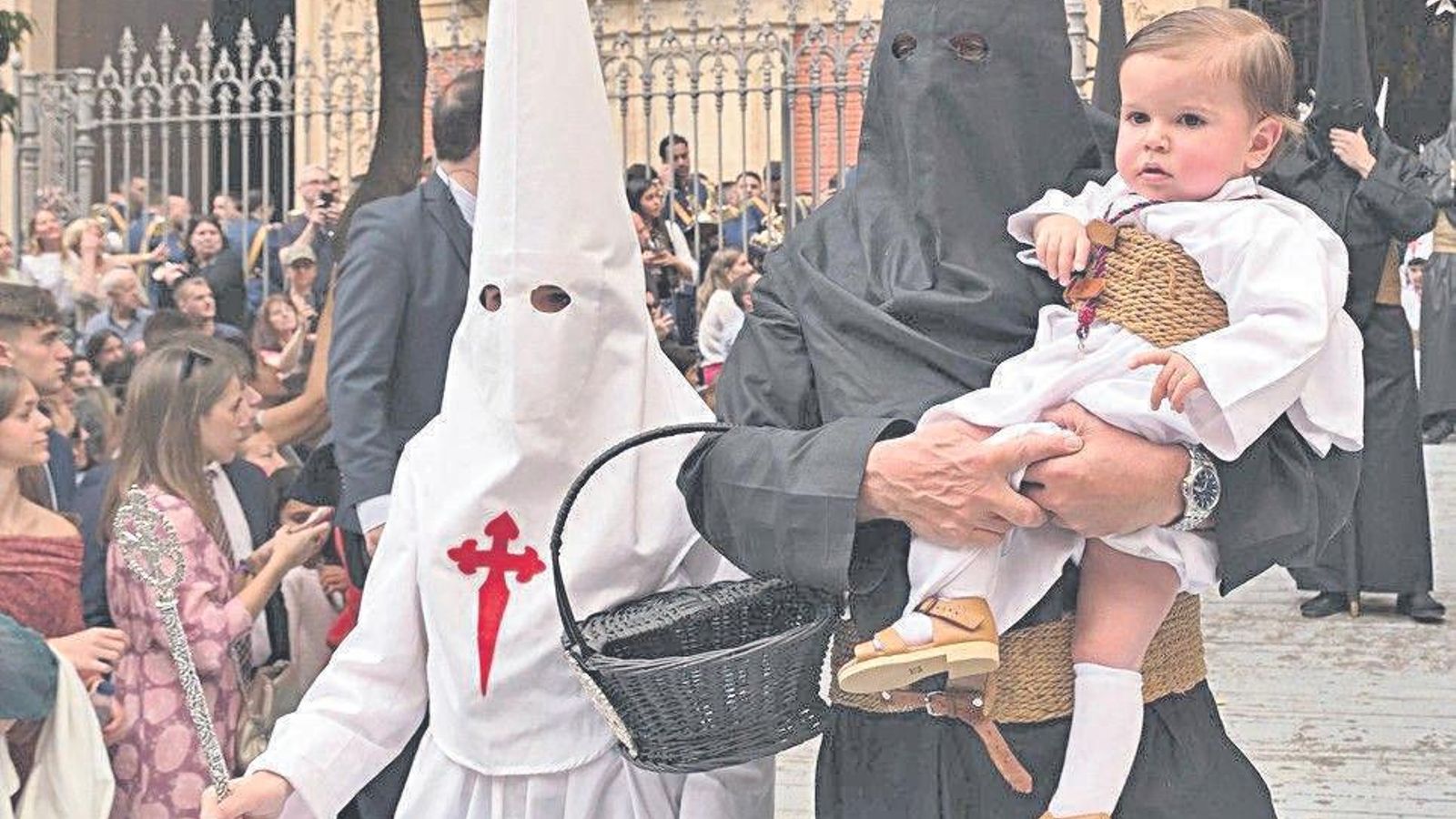 Un pequeño nazareno de la Borriquita en brazos de un espigado Nazareno del Amor.