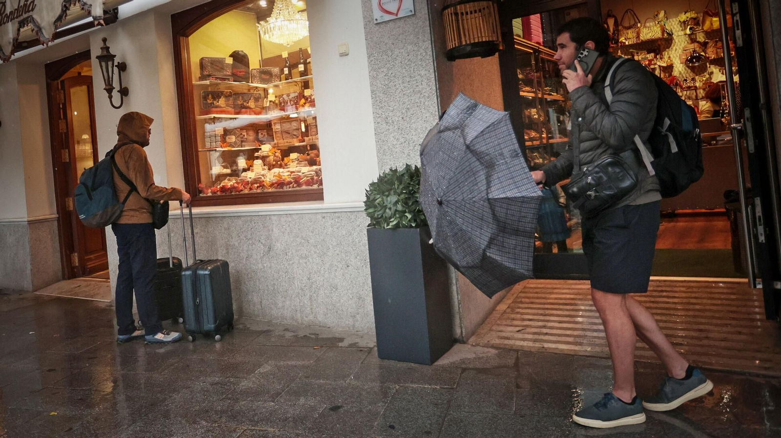 Dos personas aguardan en la plaza del Arenal el pasado sábado mientras llueve Dos personas aguardan en la plaza del Arenal el pasado sábado mientras llueve