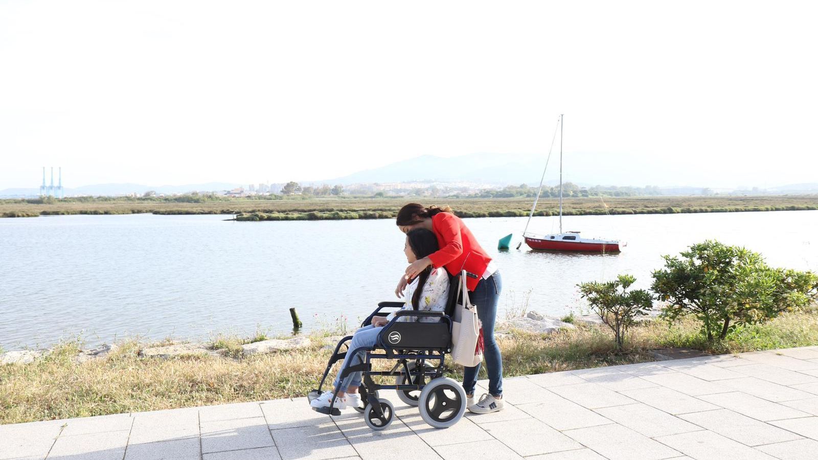 La monitora abraza a la joven mientras pasean.
