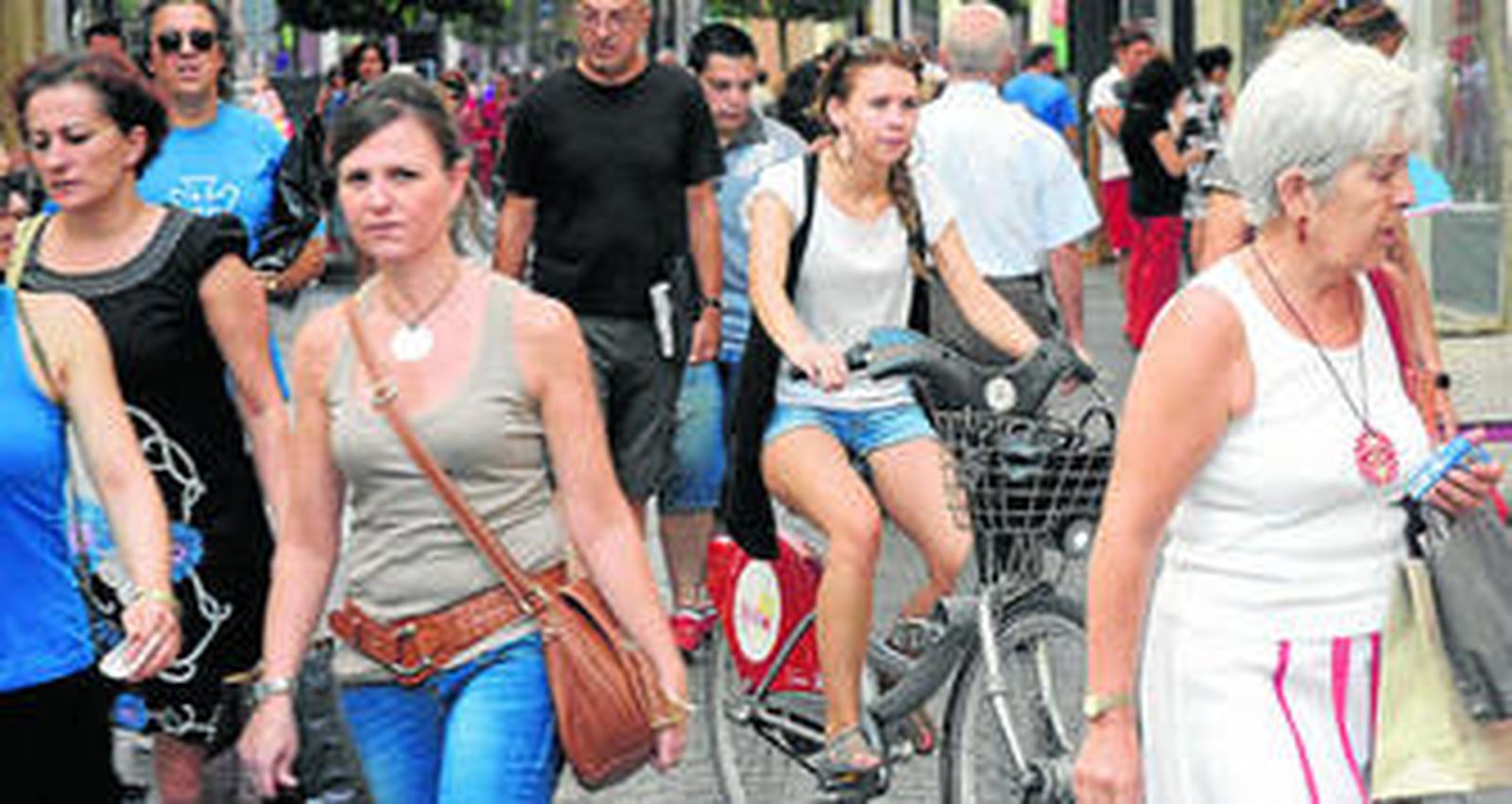 Una mujer conduce su bicicleta por la calle Tetuán.