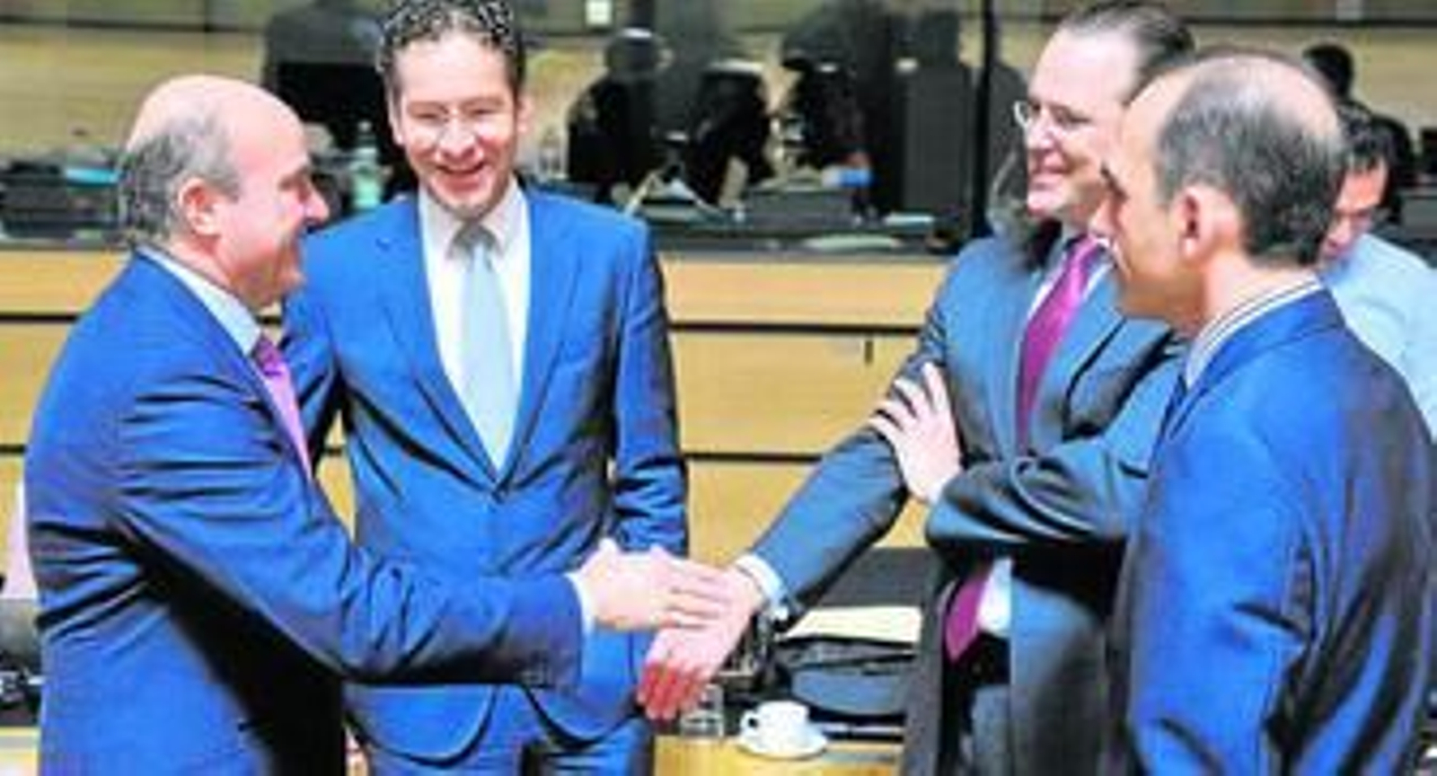 De Guindos saluda a varios miembros del Eurogrupo en una reunión de este organismo.