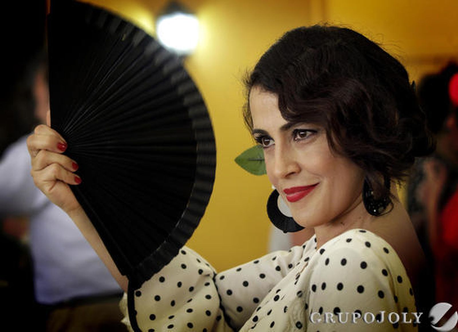 Una joven con un abanico, uno de los complementos más importantes para sofocar el calor de la Feria.

Foto: Miguel Angel Gonzalez