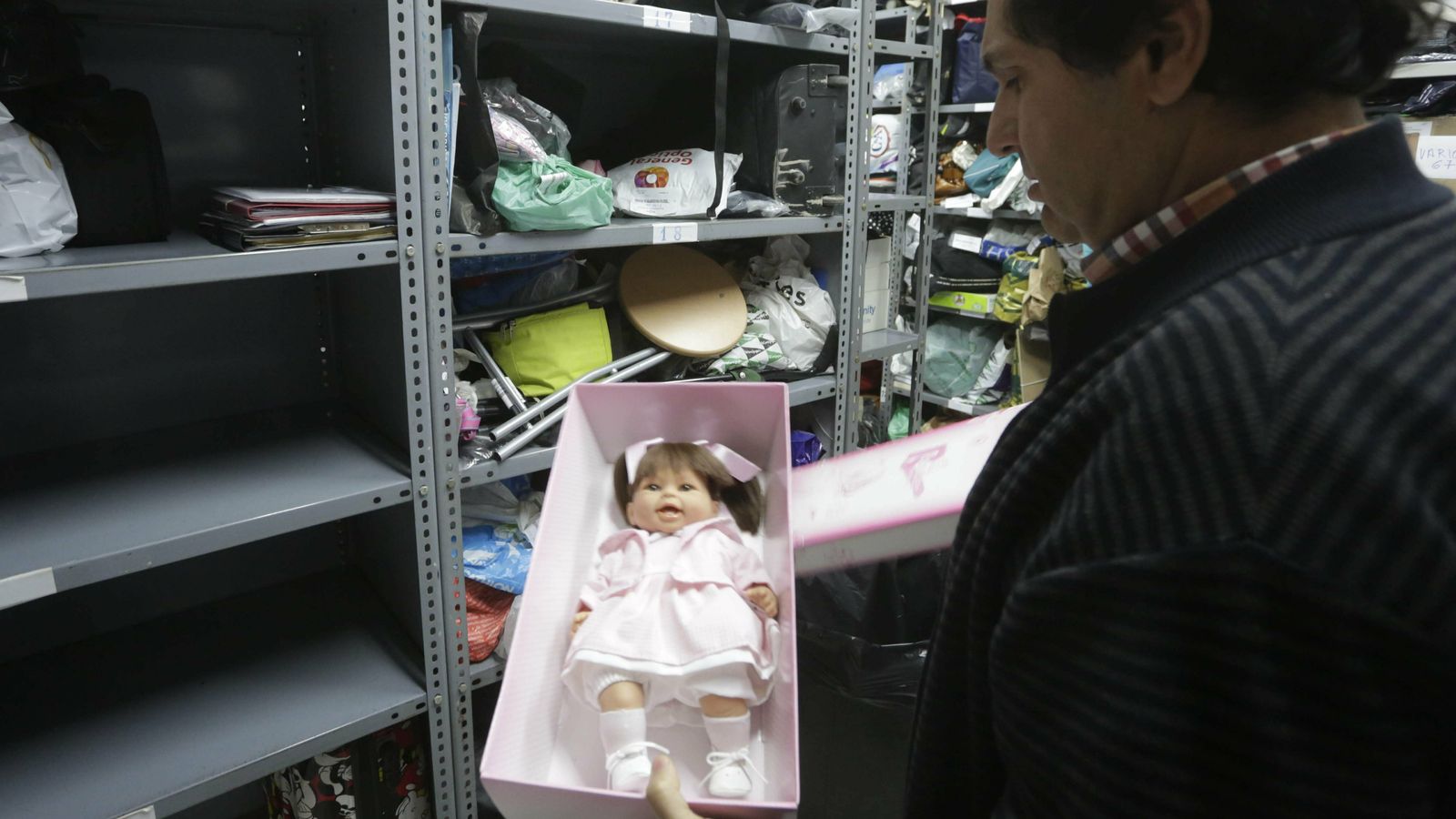 El responsable de la oficina, Máximo Lancharro, muestra un muñeca dentro de su caja almacenada.