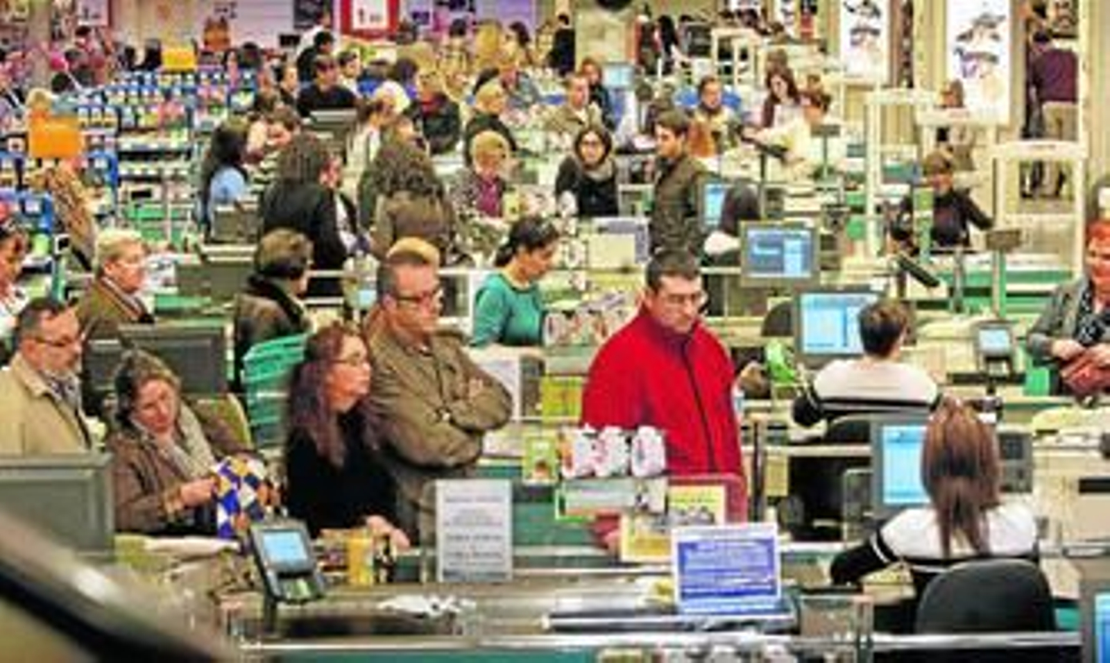 Clientes de unos grandes almacenes hacen cola en la cajas de cobro.