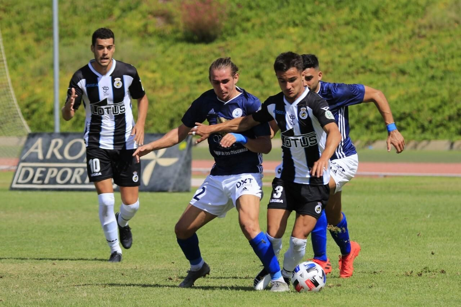 Din avanza con el balón, perseguido por dos jugadores del Marino, en el partido de la primera vuelta
