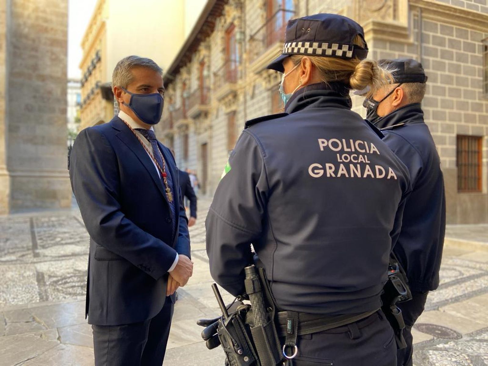 El concejal del PP, César Díaz, habla con dos policías locales de Granada