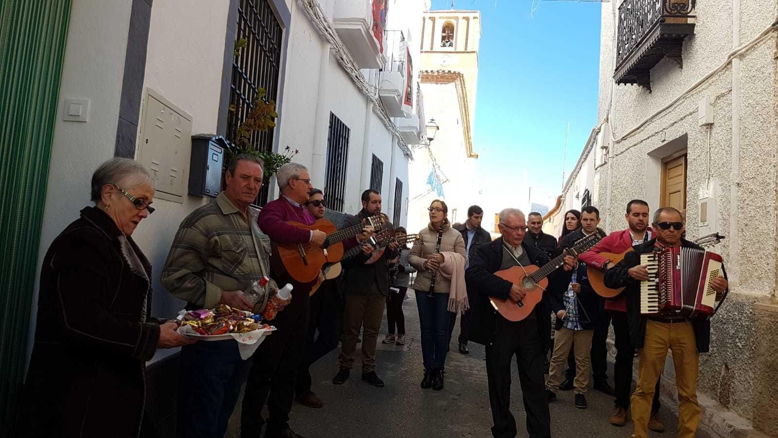 Los vecinos ofrecen dulces y licores al paso de la cuadrilla de músicos