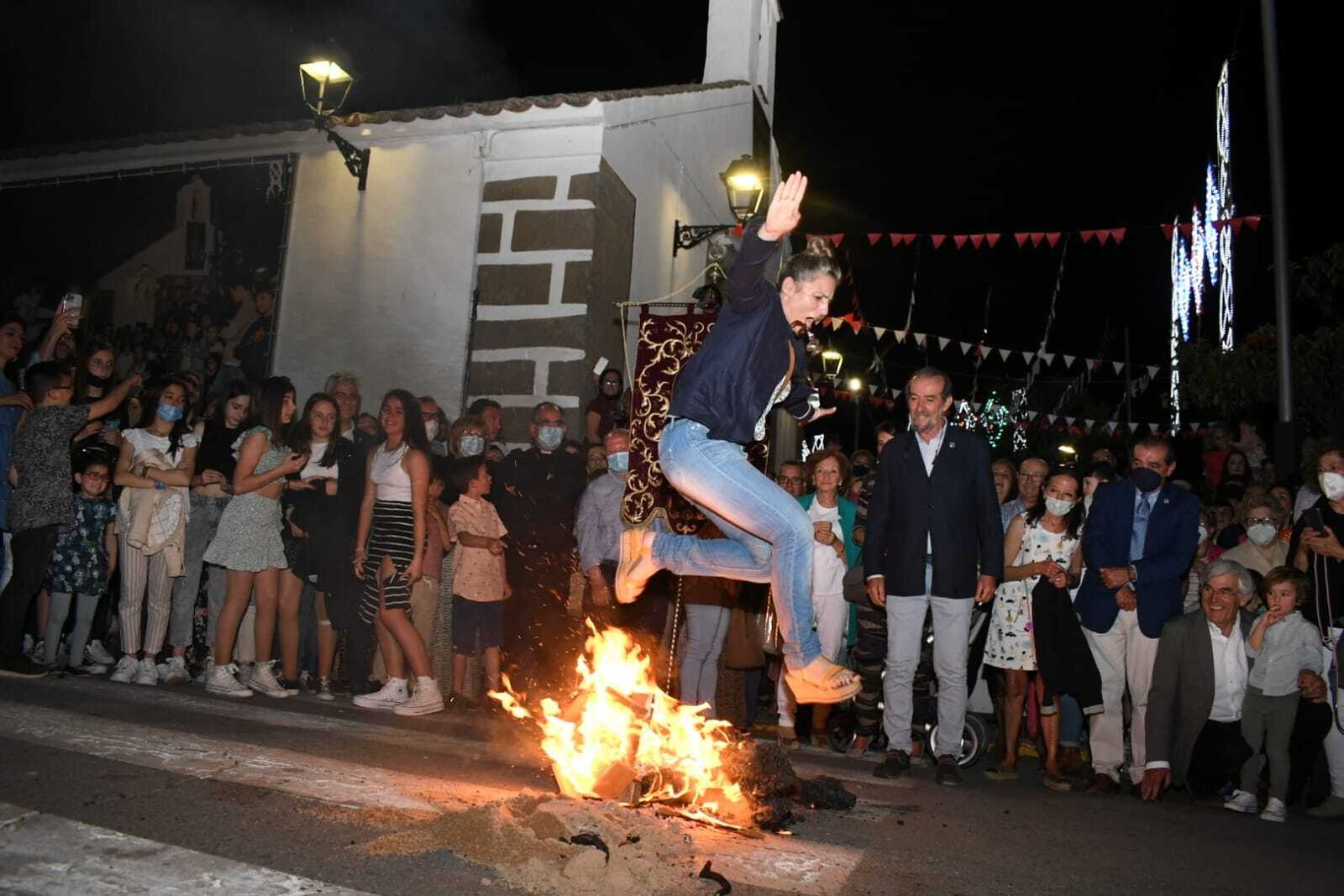 Una joven salta el corcho ardiendo con sandalias de cuña.