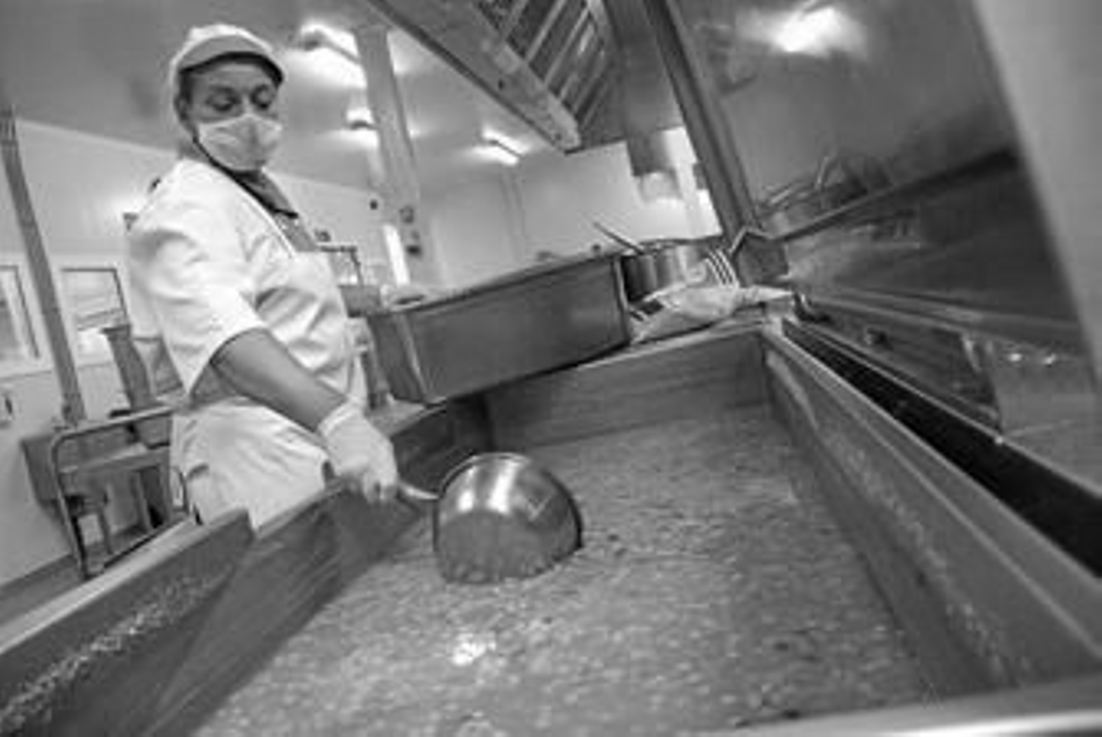 Una cocinera de Serunión prepara una sopa en la cocina central de Málaga.