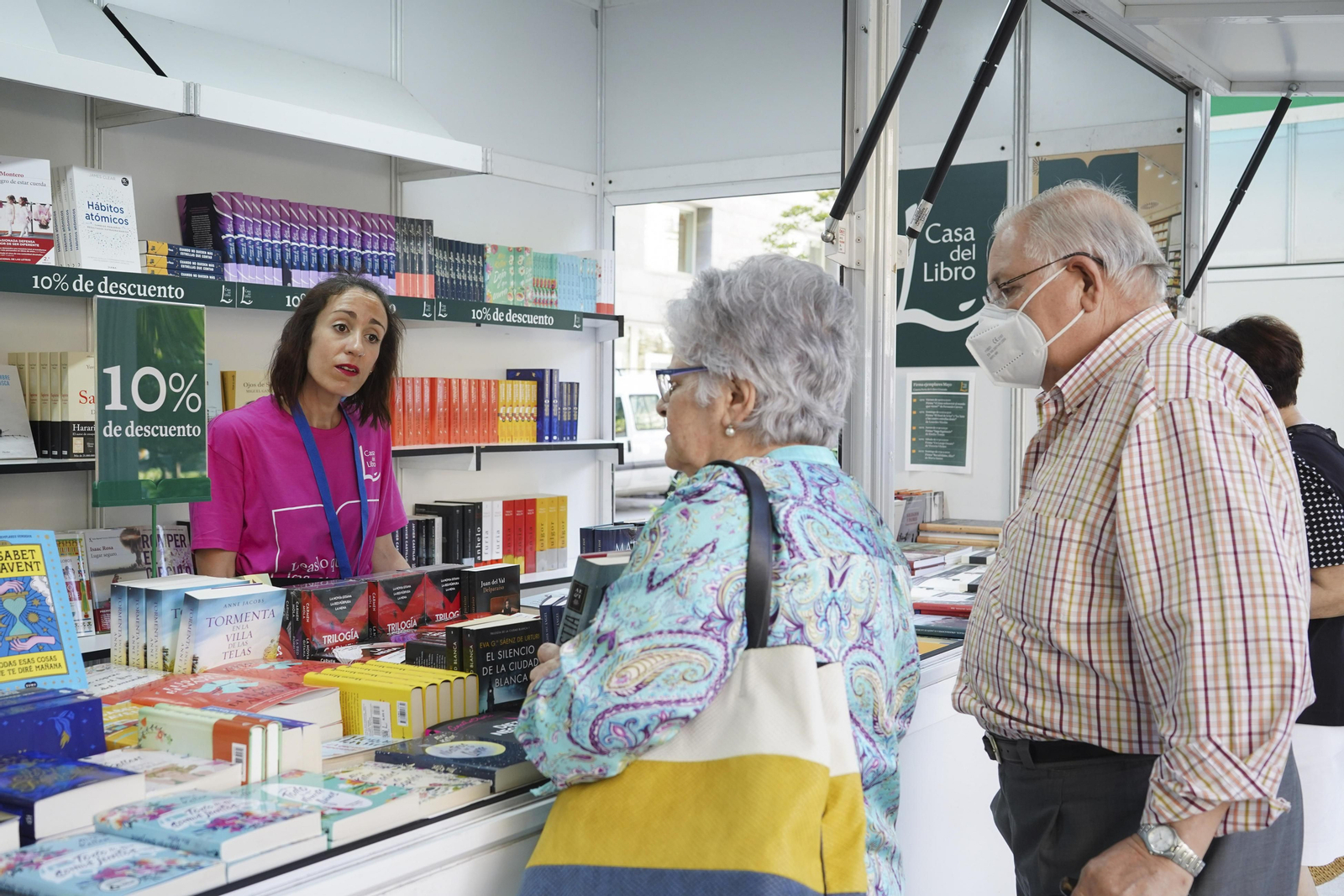 Varios compradores consultan las novedades de una de las casetas.