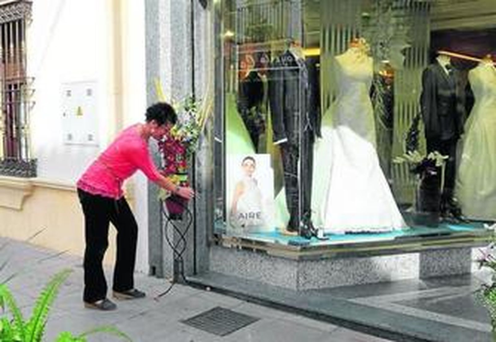 Una comerciante arregla un escaparate participante.