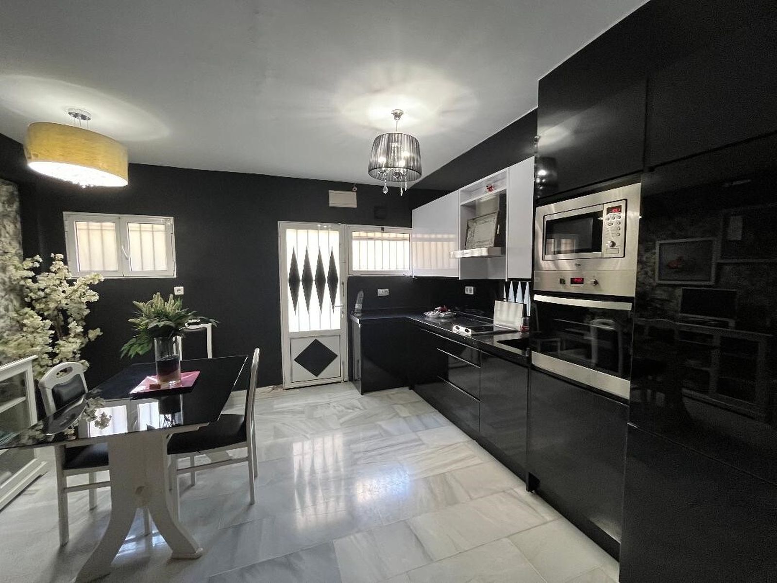Cocina. Utiliza el color negro  y blanco para  su mobiliario, paredes y tapicerías que combina con el mármol