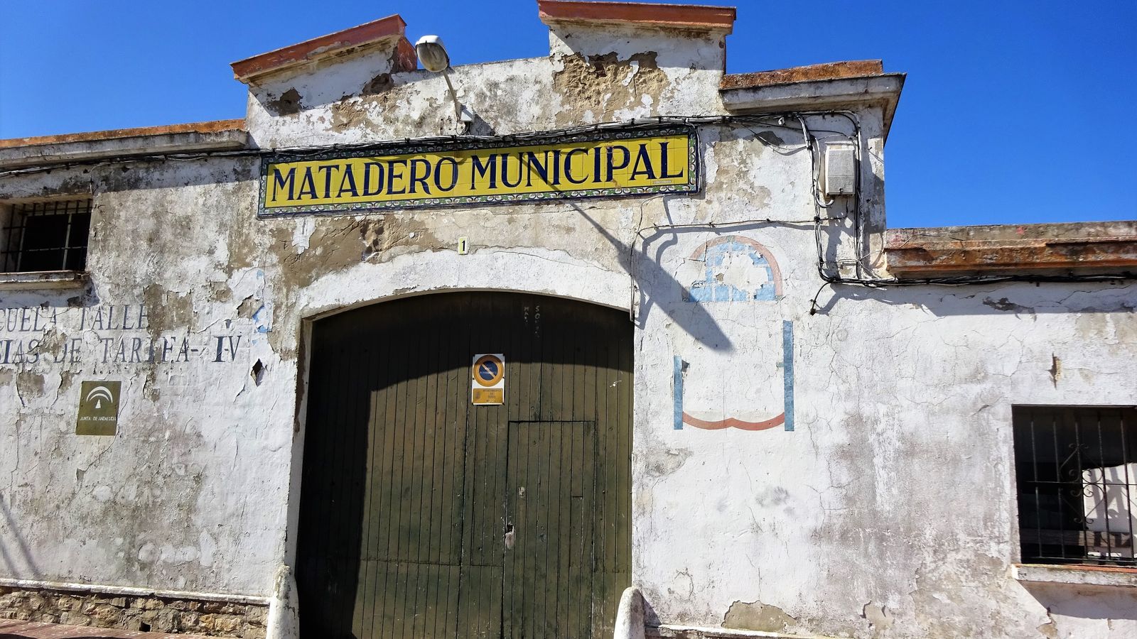 Fachada y puerta principal del último matadero tarifeño, inaugurado en 1957. Lleva cerrado treinta años y sus servicios asumidos por el matadero comarcal en La Línea.