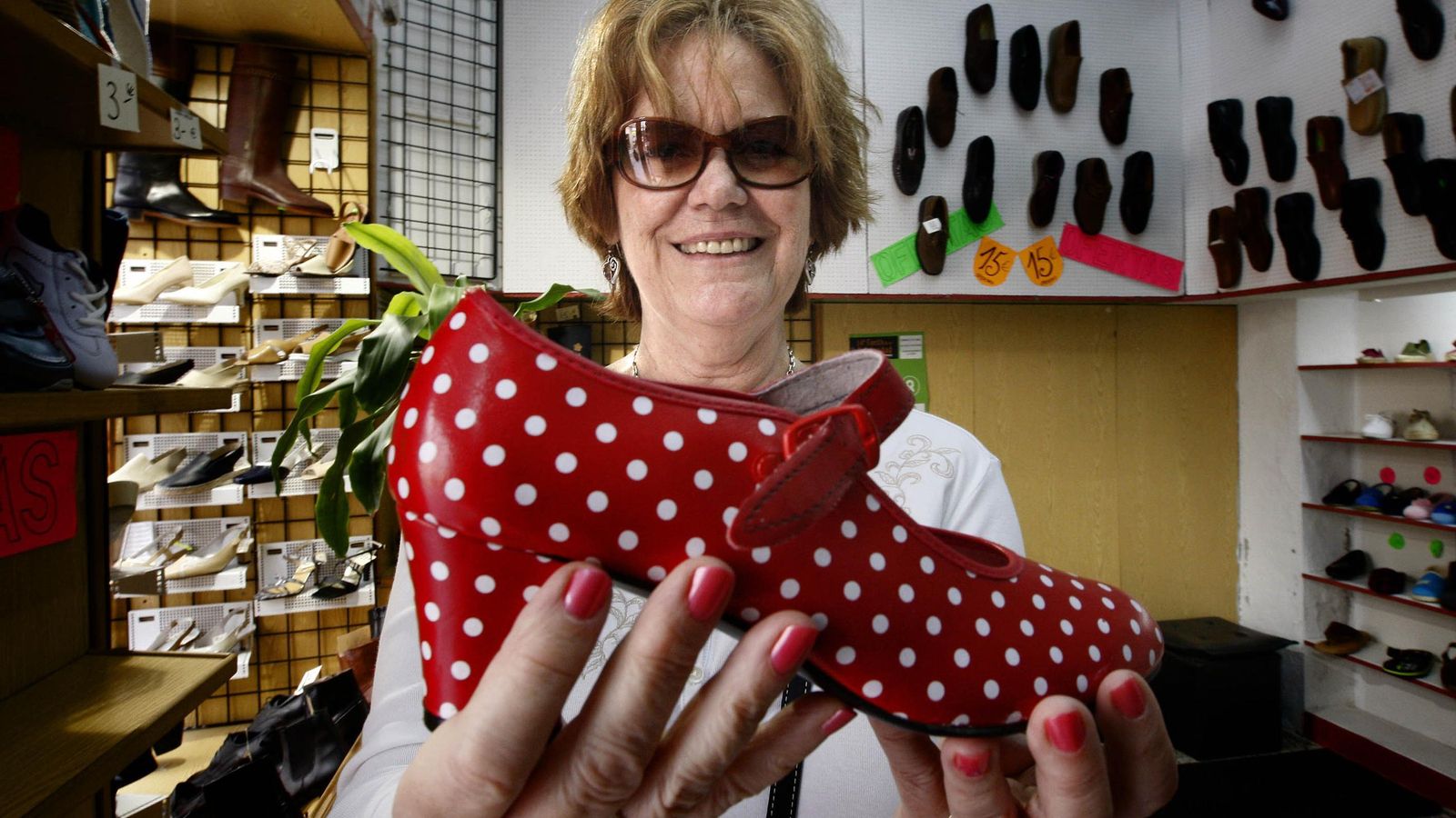 Una extranjera muestra un zapato de flamenca en un comercio  de Cádiz