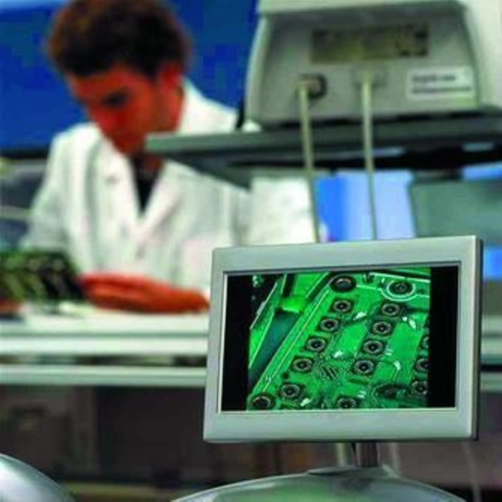 Un trabajador, al fondo, observa en una imagen de archivo la microelectrónica de un teléfono móvil en Vitelcom.