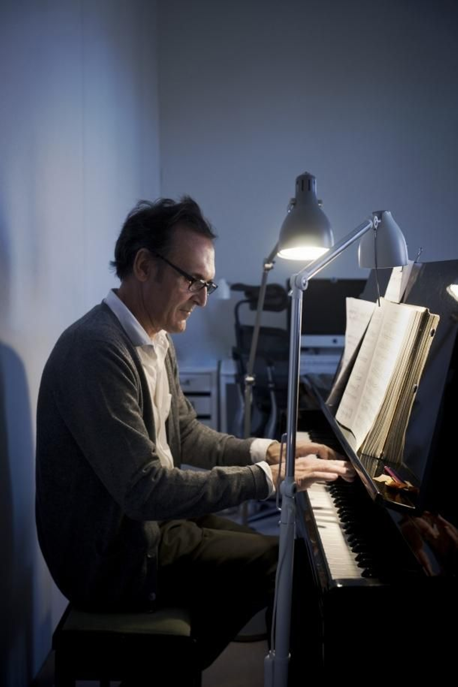 El músico donostiarra trabajando con su piano, su partitura y su flexo.