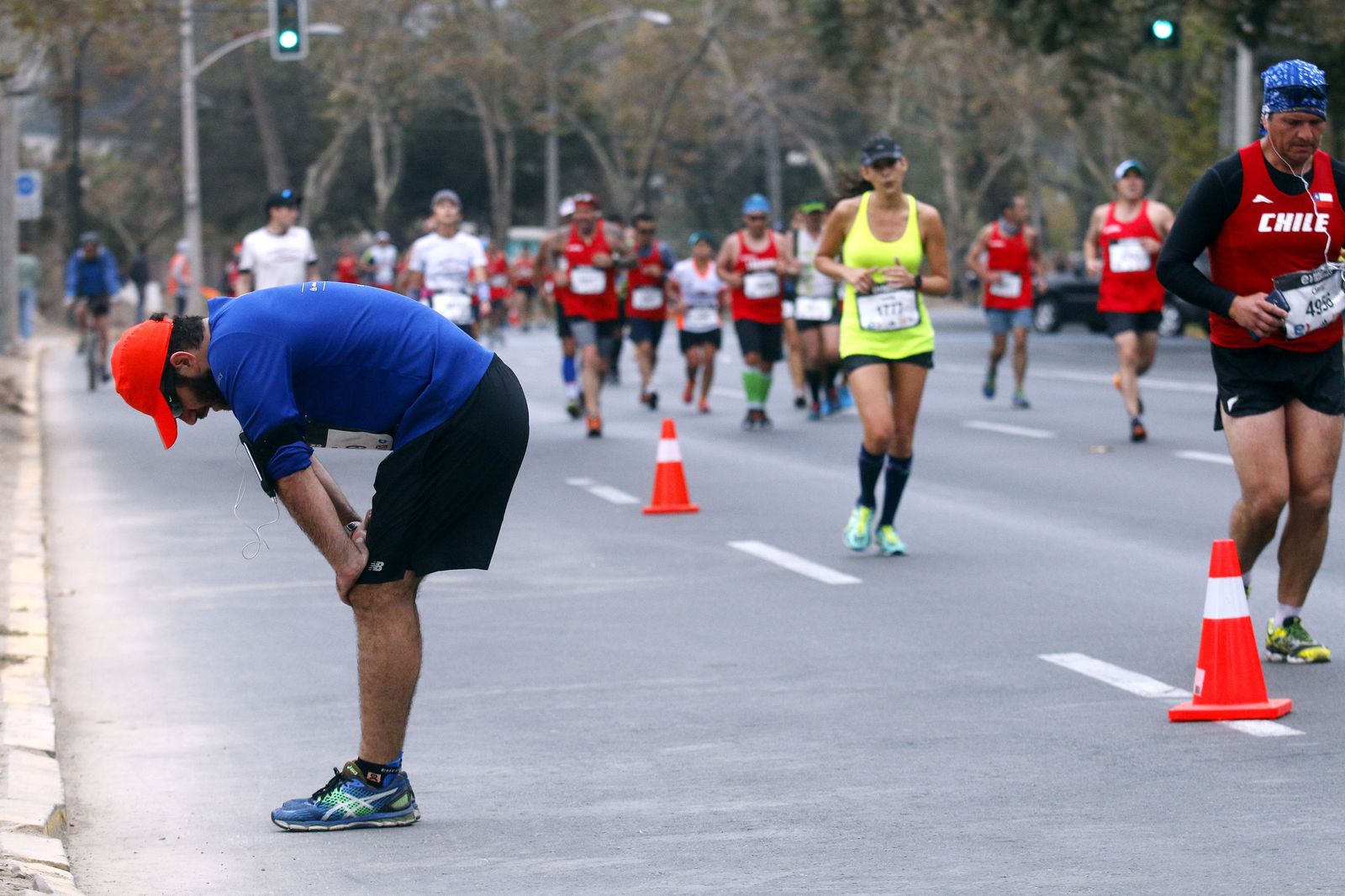 Un corredor con problemas en sus piernas se detiene en la Maratón de Santiago de Chile.