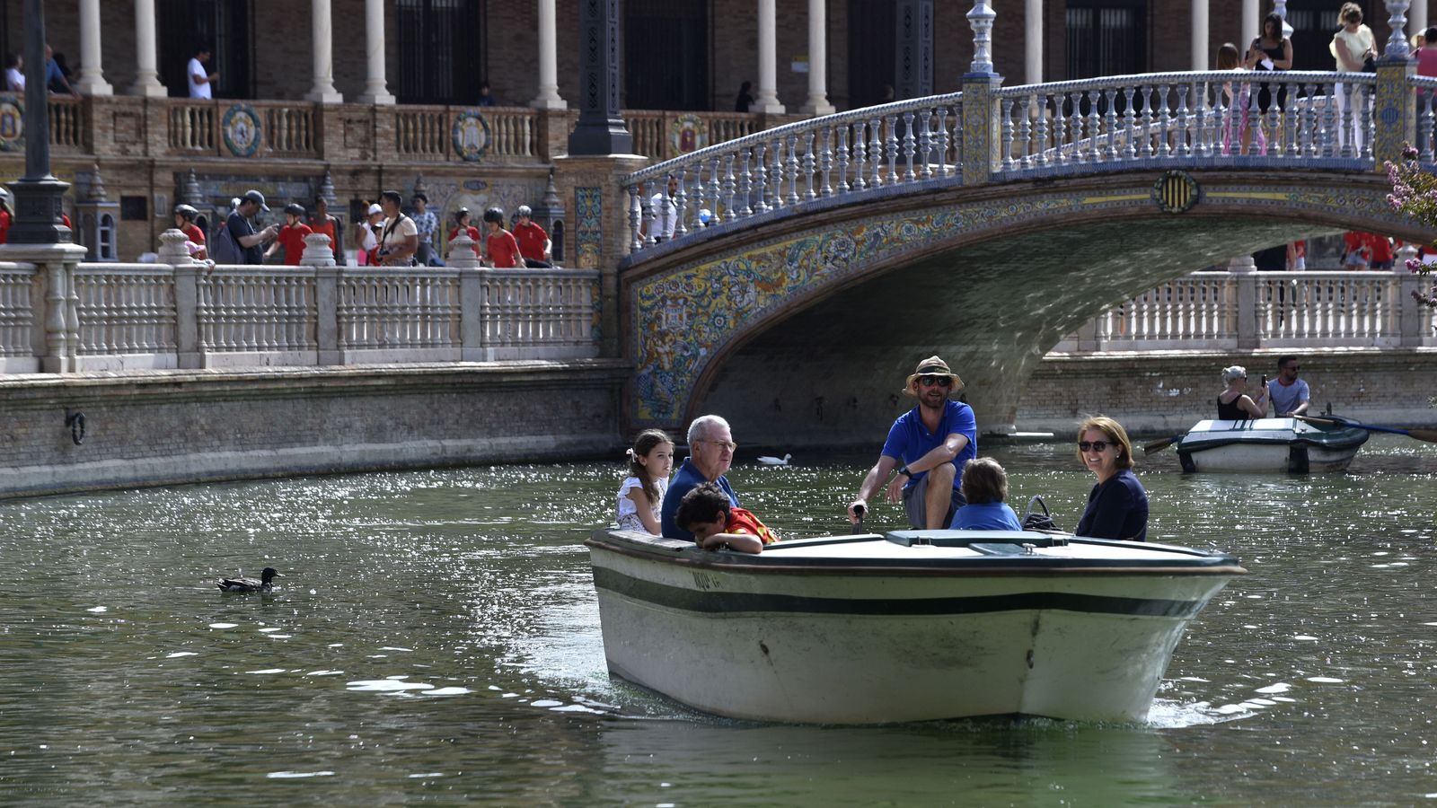 Turistas en la Plaza de España, disfrutando de la ría.