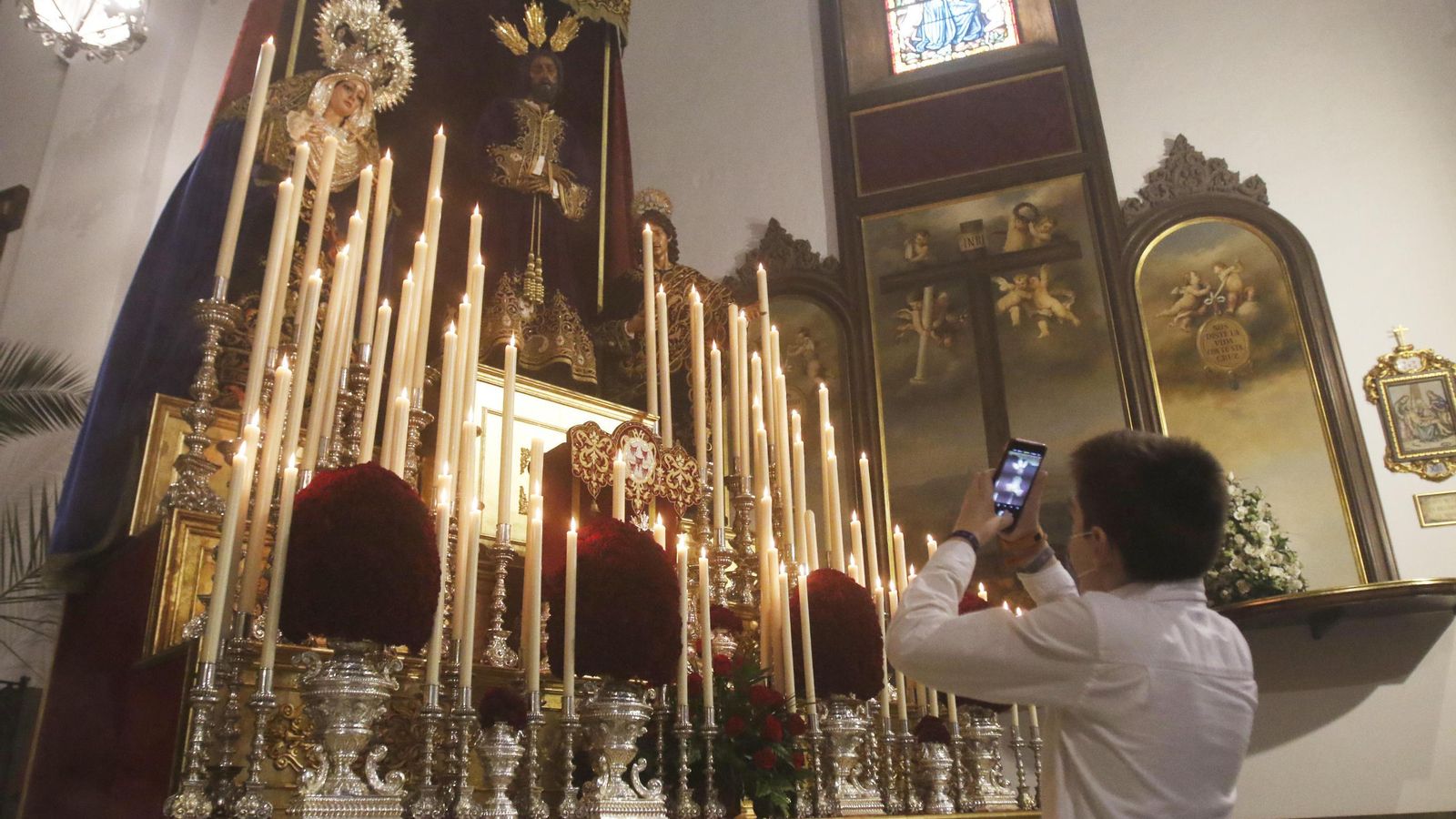 Un devoto fotografía a los titulares de la hermandad de la Sangre.