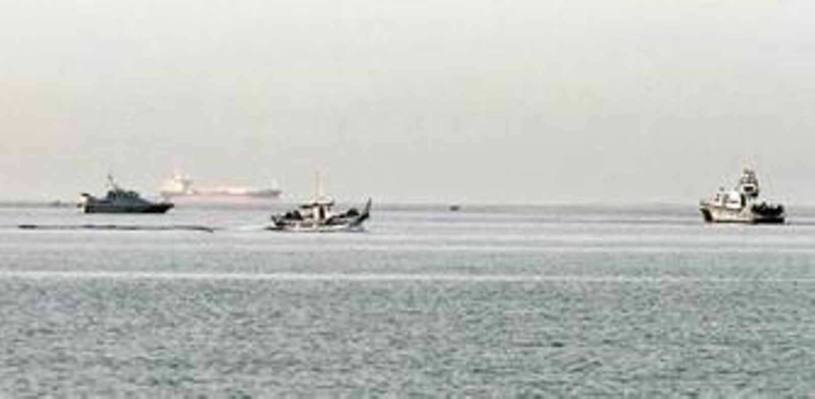 Un pesquero y una embarcación de la Guardia Civil, en la bahía, junto a un barco de la Royal Navy.