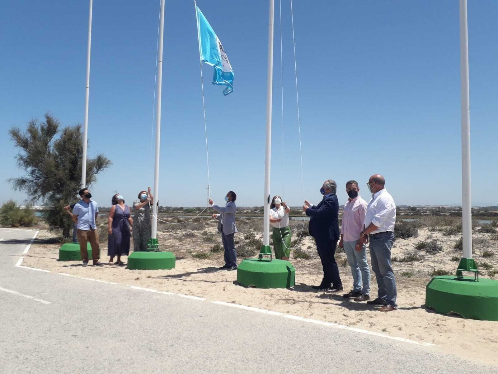 Momento del izado de las banderas en la playa de Sancti Petri.
