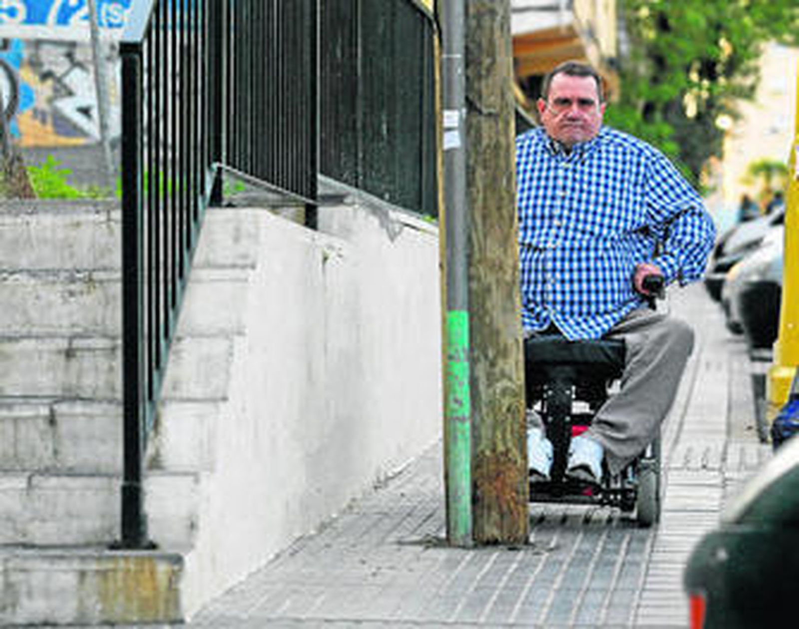 Francisco Gómez, uno de los afectados, en silla de ruedas junto al poste.