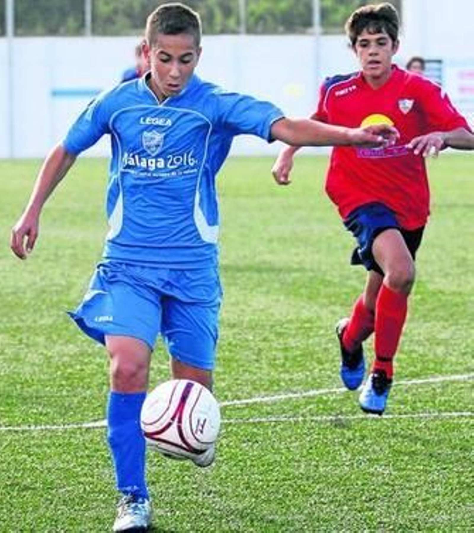 Un futbolista del Puerto Malagueño controla el balón en el aire ante la llegada de dos rivales. Un futbolista del Puerto Malagueño controla el balón en el aire ante la llegada de dos rivales.