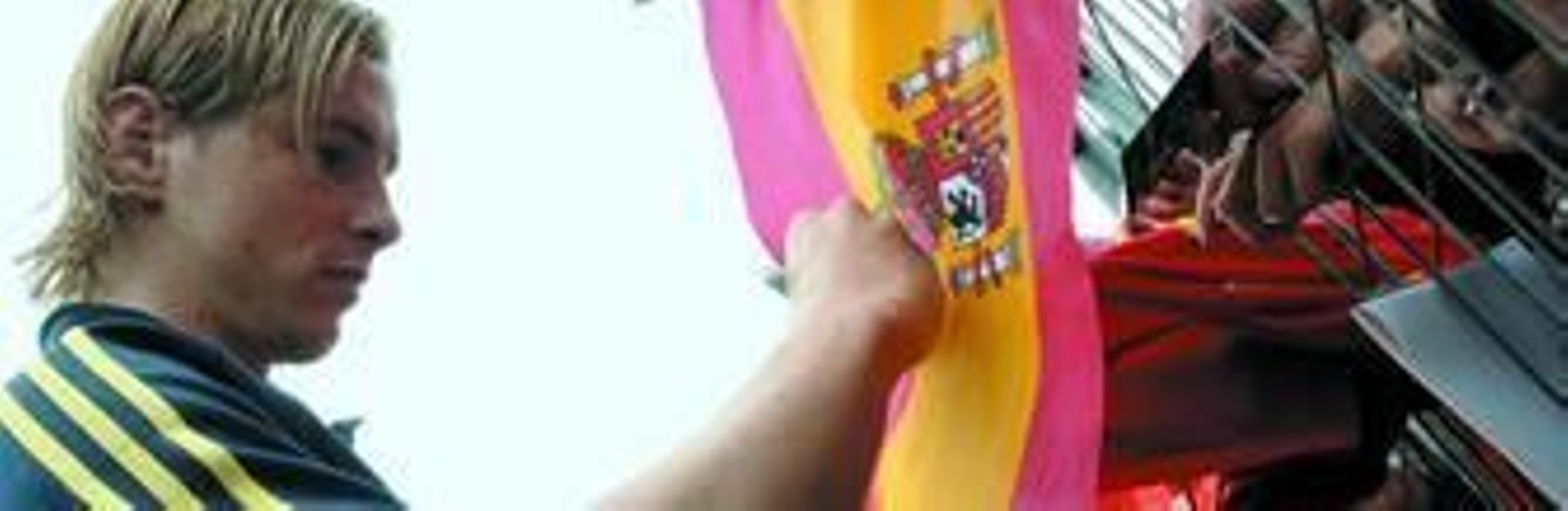 Fernando Torres estampa su firma en una bandera de España en la zona en la que los aficionados presenciaron en el entrenamiento de ayer.