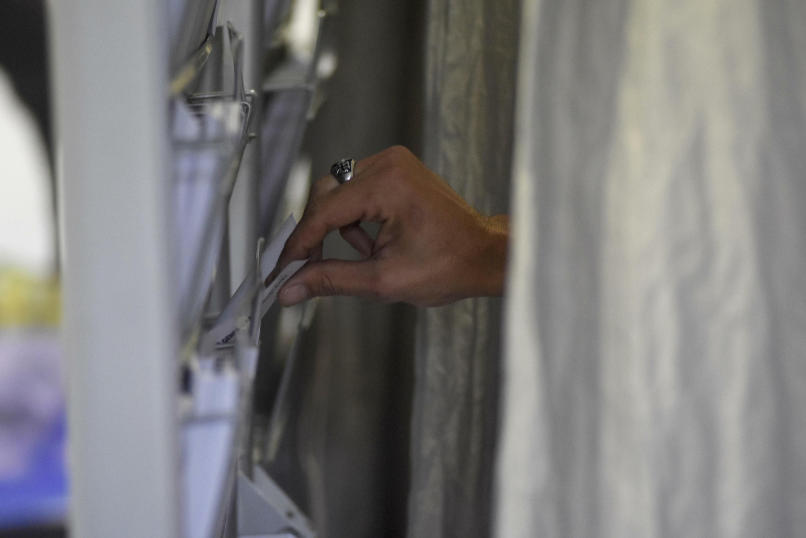 Una mujer coge una papeleta en un colegio de la capital.