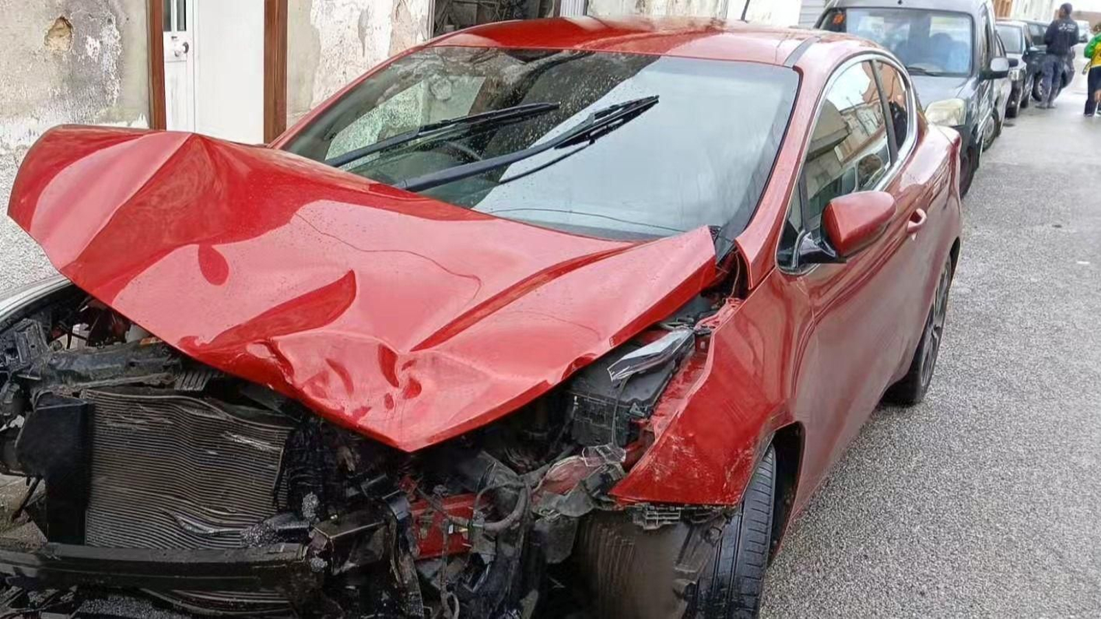 Uno de los coches implicados, de color rojo, sufrió un impacto que destrozó completamente su parte delantera.