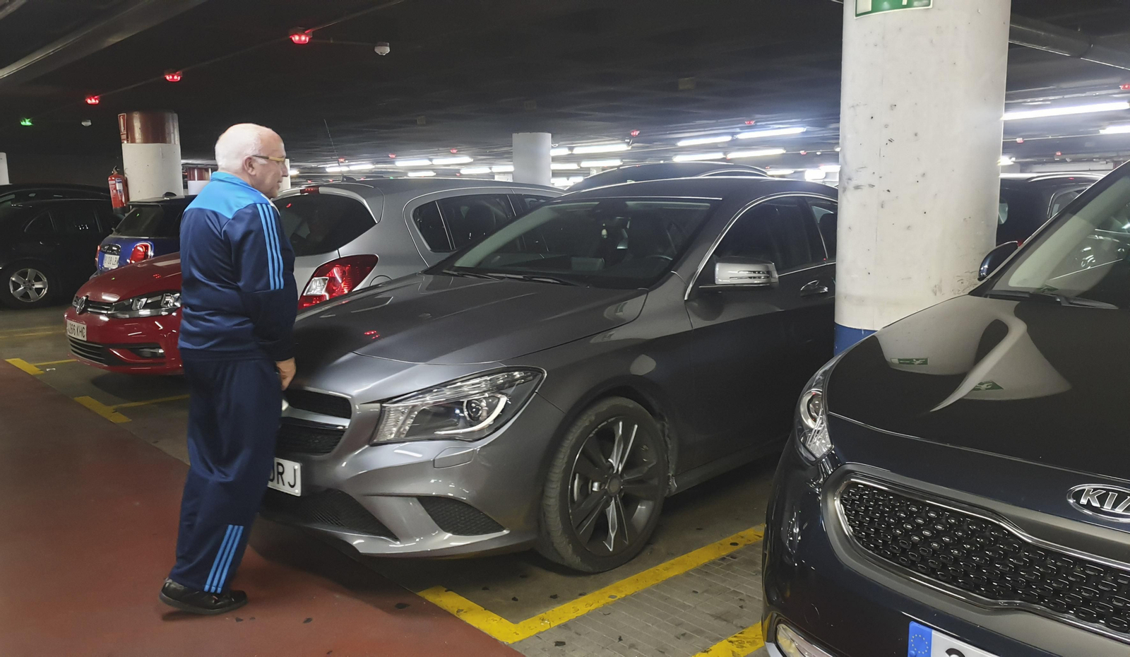 Un usuario del aparcamiento de La Marina empuja su vehículo.