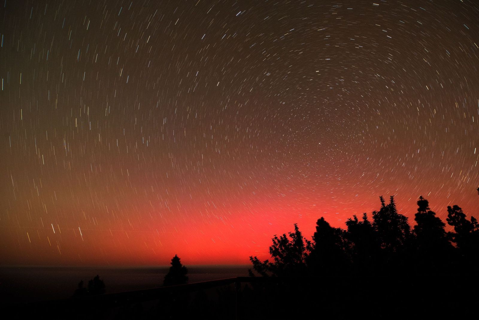 Aurora boreal visible desde Canarias durante una tormenta geomagnética intensa. En latitudes bajas como el sur de España el fenómeno suele aparecer como un resplandor rojizo muy tenue sobre el horizonte norte.