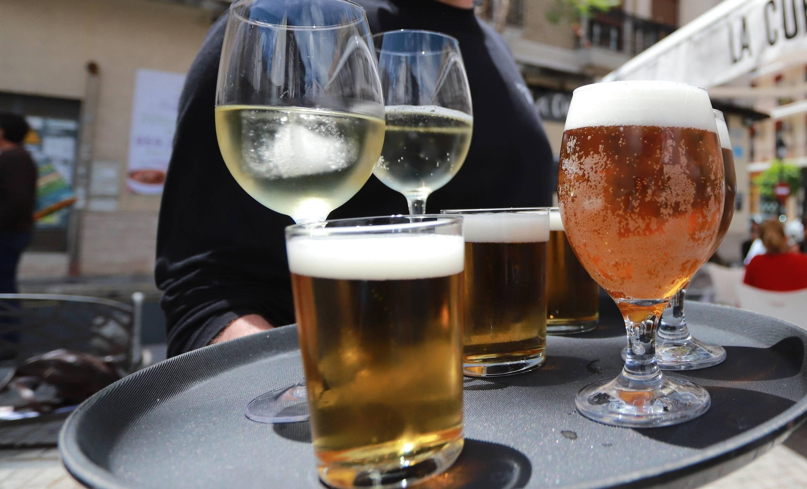 Un camarero con una bandeja con bebidas