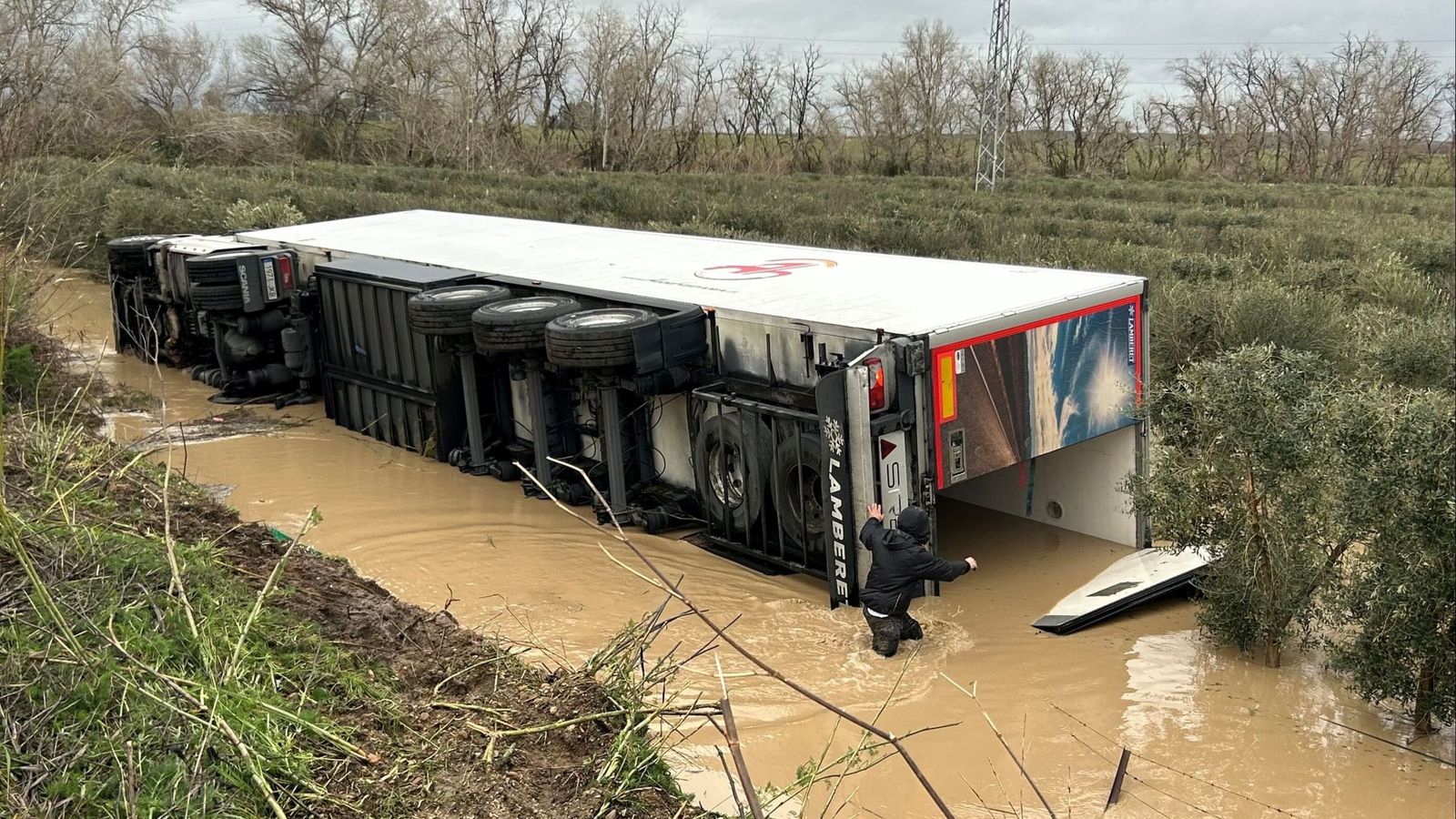 El camión seguía el sábado totalmente volcado y parcialmente anegado junto al terraplén de unos tres metros por el que cayó.