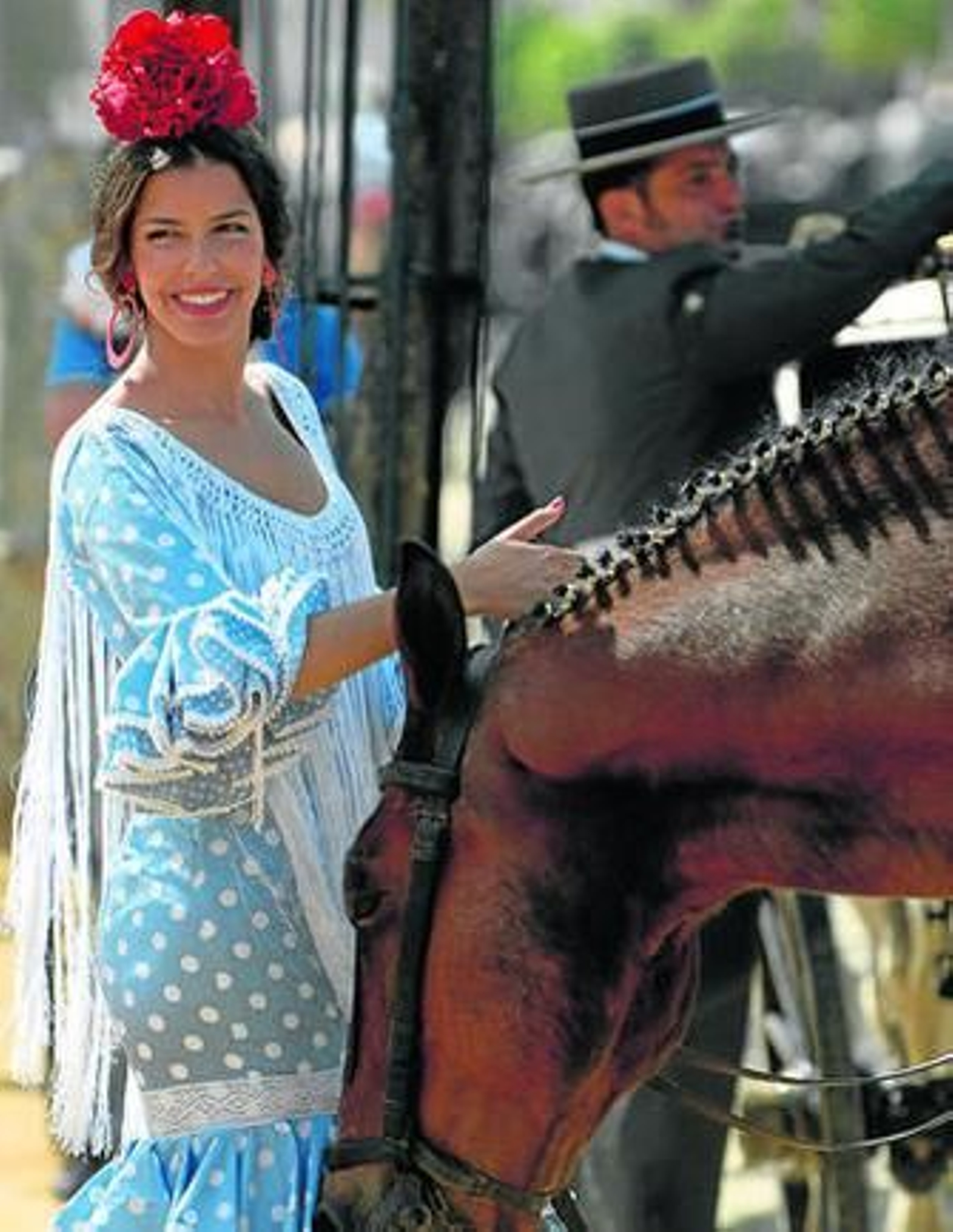 Una flamenca junto a un caballo en la tarde de ayer en el real.