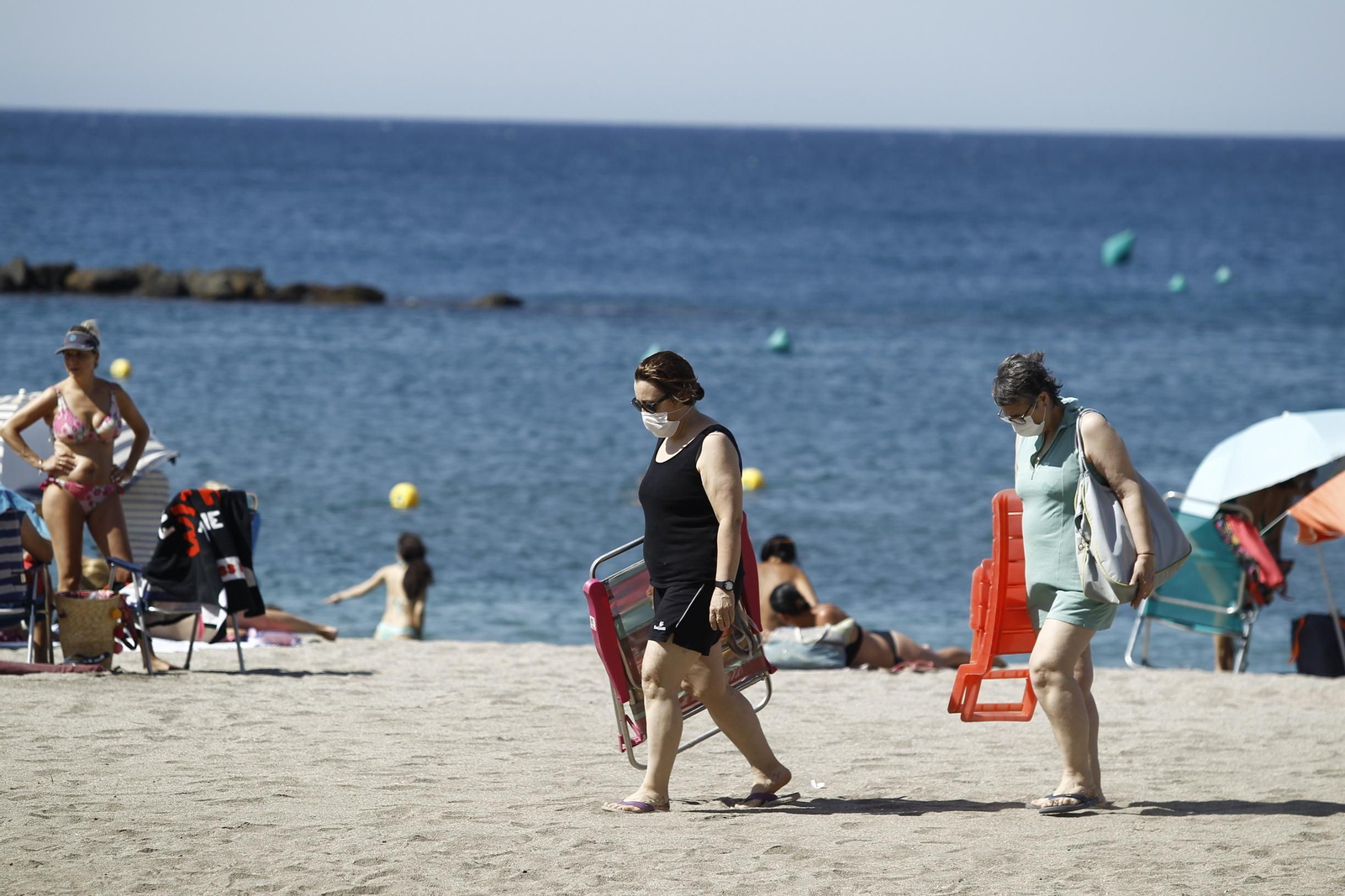 Dos mujeres con mascarillas en la playa del Zapillo, en Almería