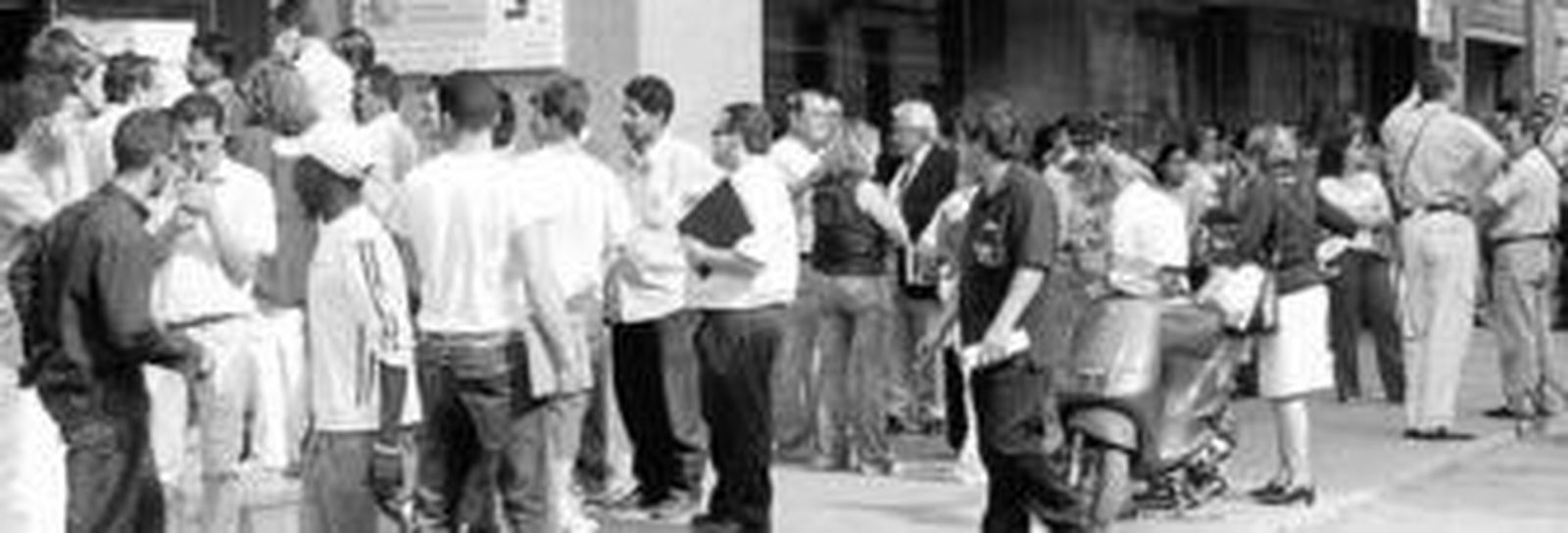 Personas de varias nacionalidades, en la puerta de una oficina de la Seguridad Social en Granada.