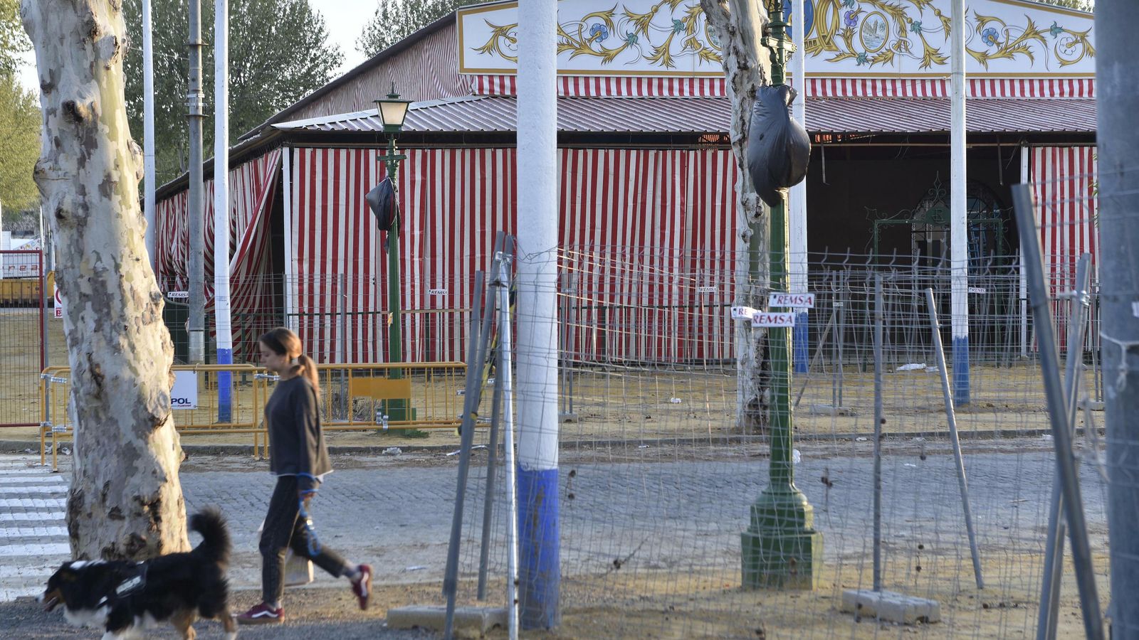 Una joven pasea con su perro ayer junto a una caseta con el montaje avanzado.