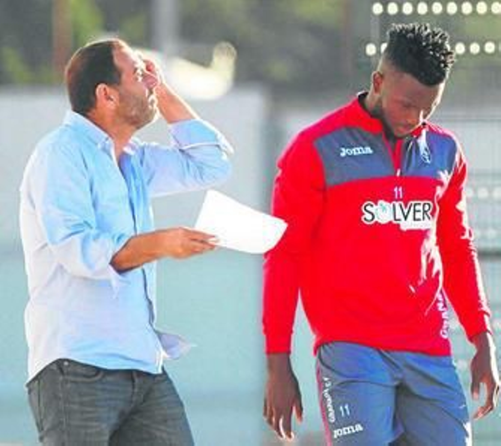Isaac Success escucha atentamente al director de Comunicación del Granada CF, Javier Rufete.