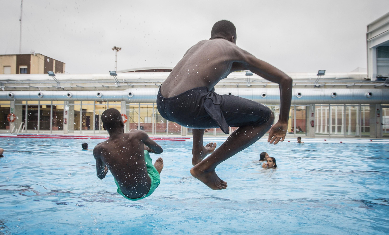 Niños del 'baño social' se divierten saltando al agua.